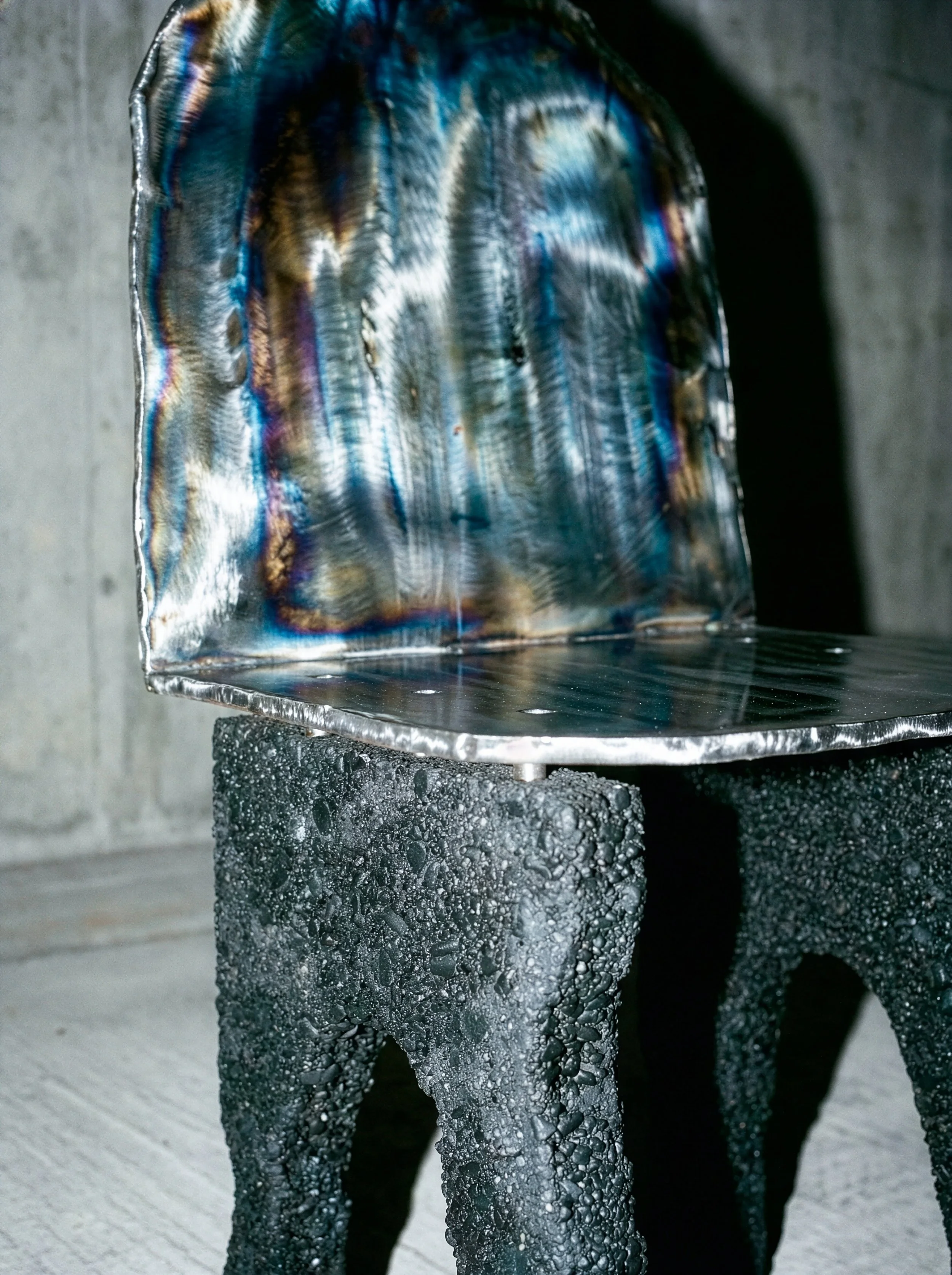 Une chaise en verre tachée de buée ou de condensation, placée sur une table en pierre noire.  PAUL HARDY