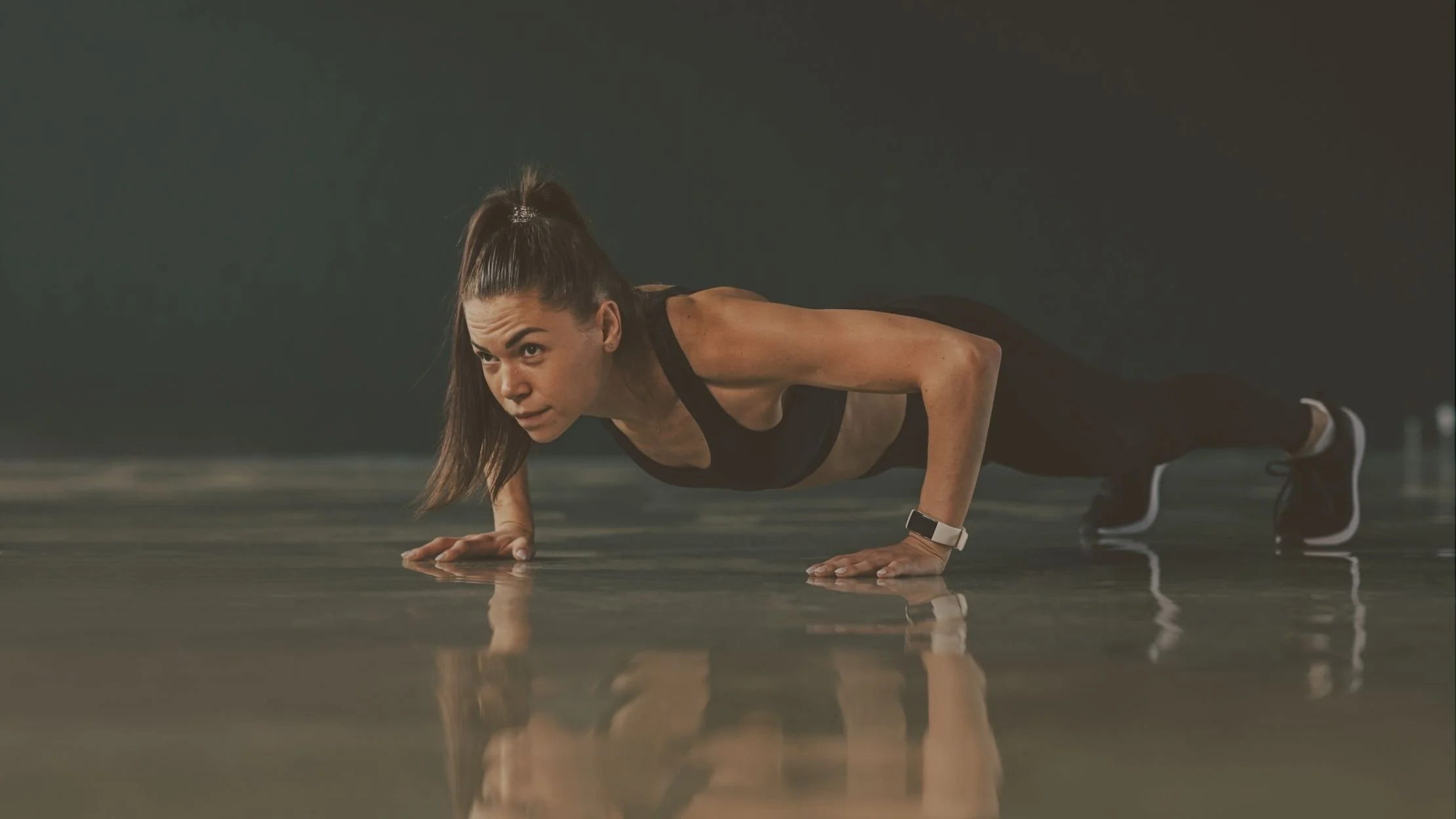 A woman doing push-ups on a gym floor