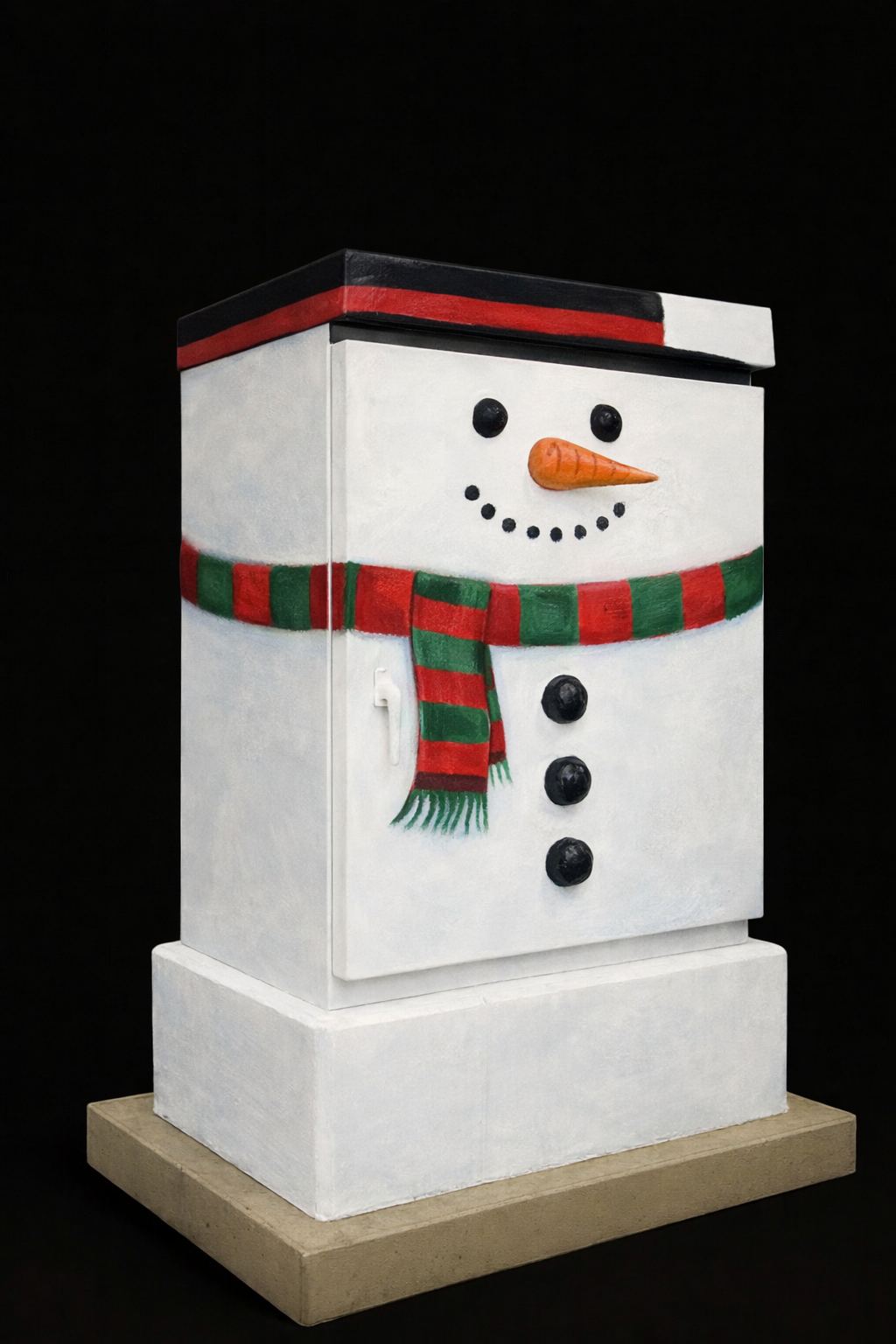 Decorative snowman-shaped container painted with a face, carrot nose, black eyes and mouth, wearing a red and green striped scarf, against a black background.