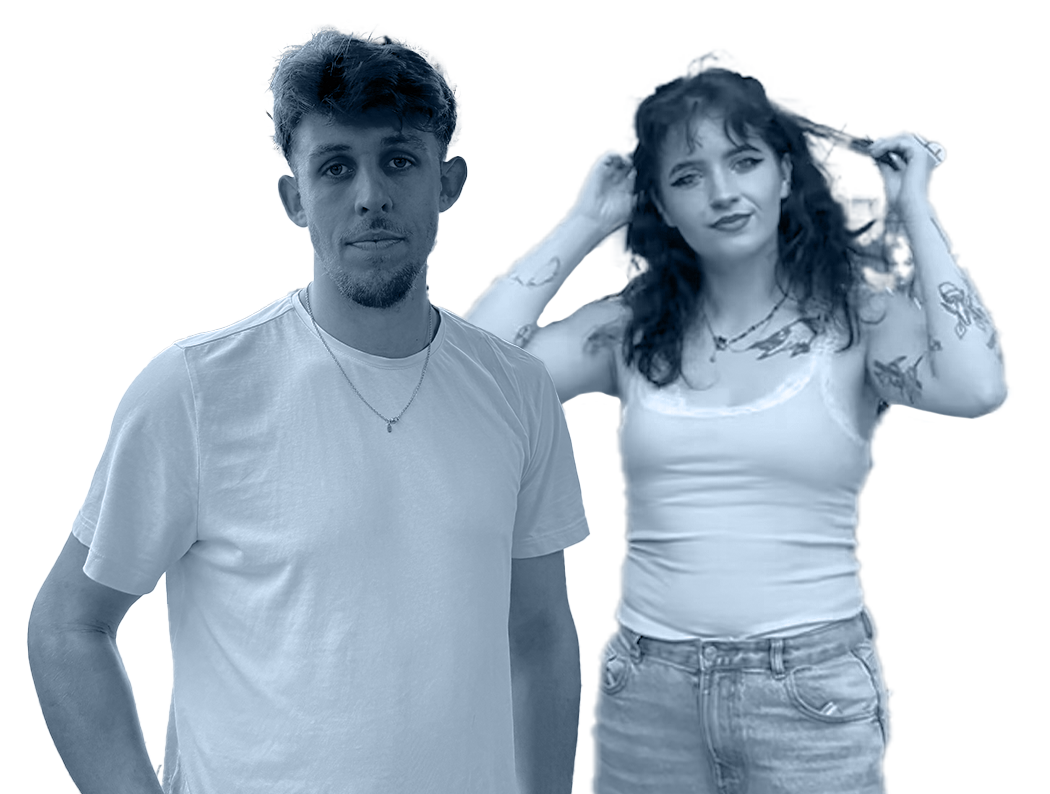 A man with short hair and a beard wearing a plain white t-shirt, standing next to a woman with curly hair and tattoos on her arms, wearing a white sleeveless top and jeans, posing with her hands in her hair.