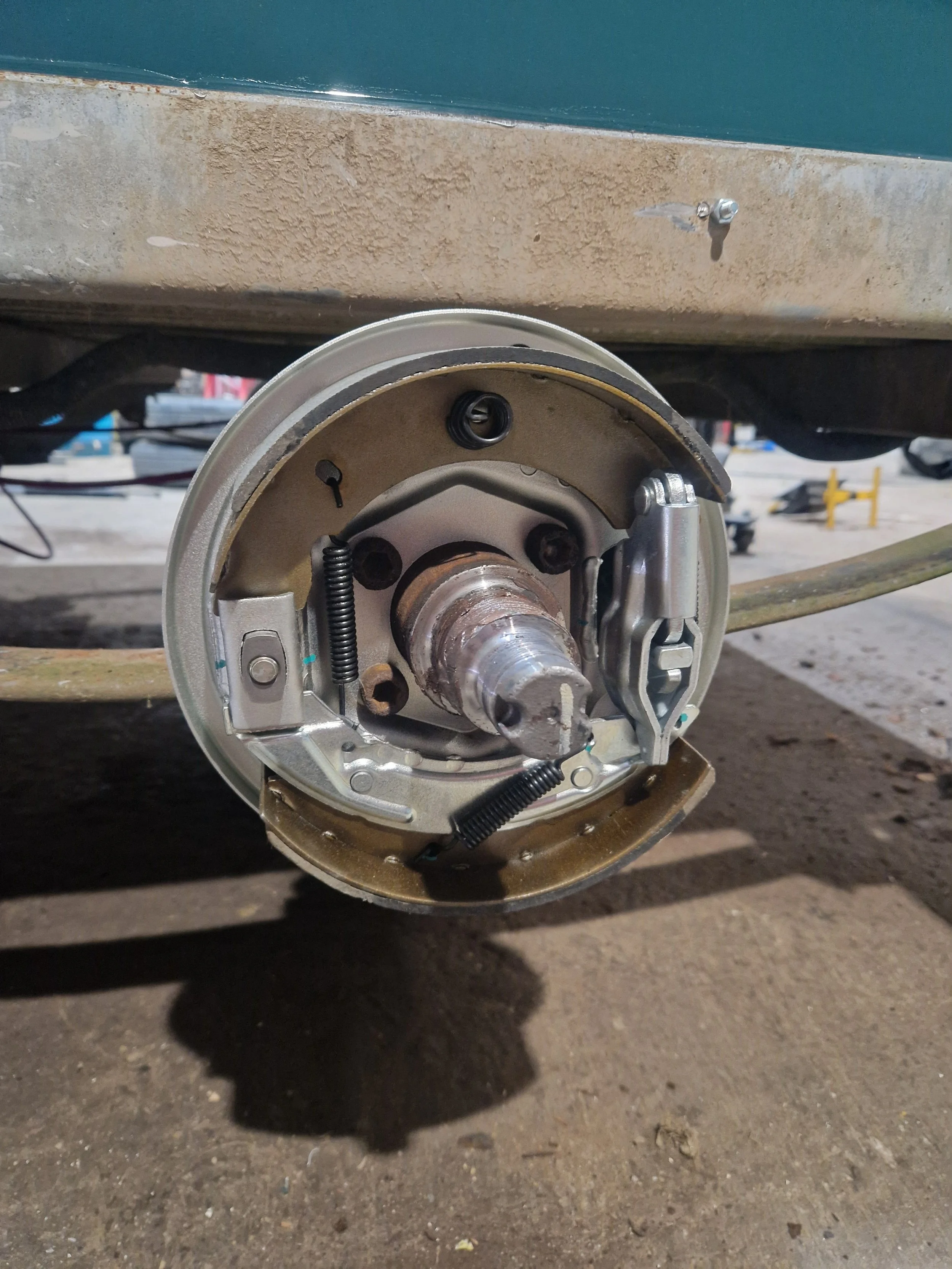 Close-up of a boat trailer wheel hub with the tire removed, exposing the brake assembly and hub components.