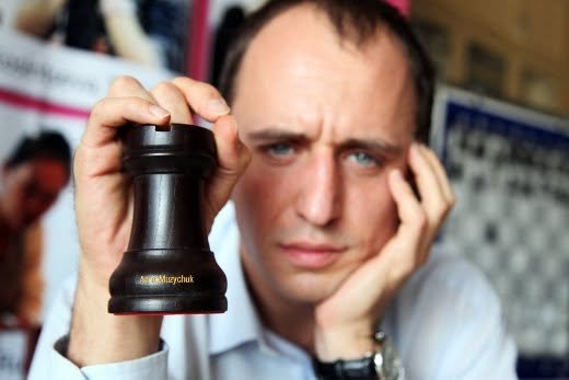 Evgenij Miroshnichenko holding a black rook with Anna Muzychuk's name on it