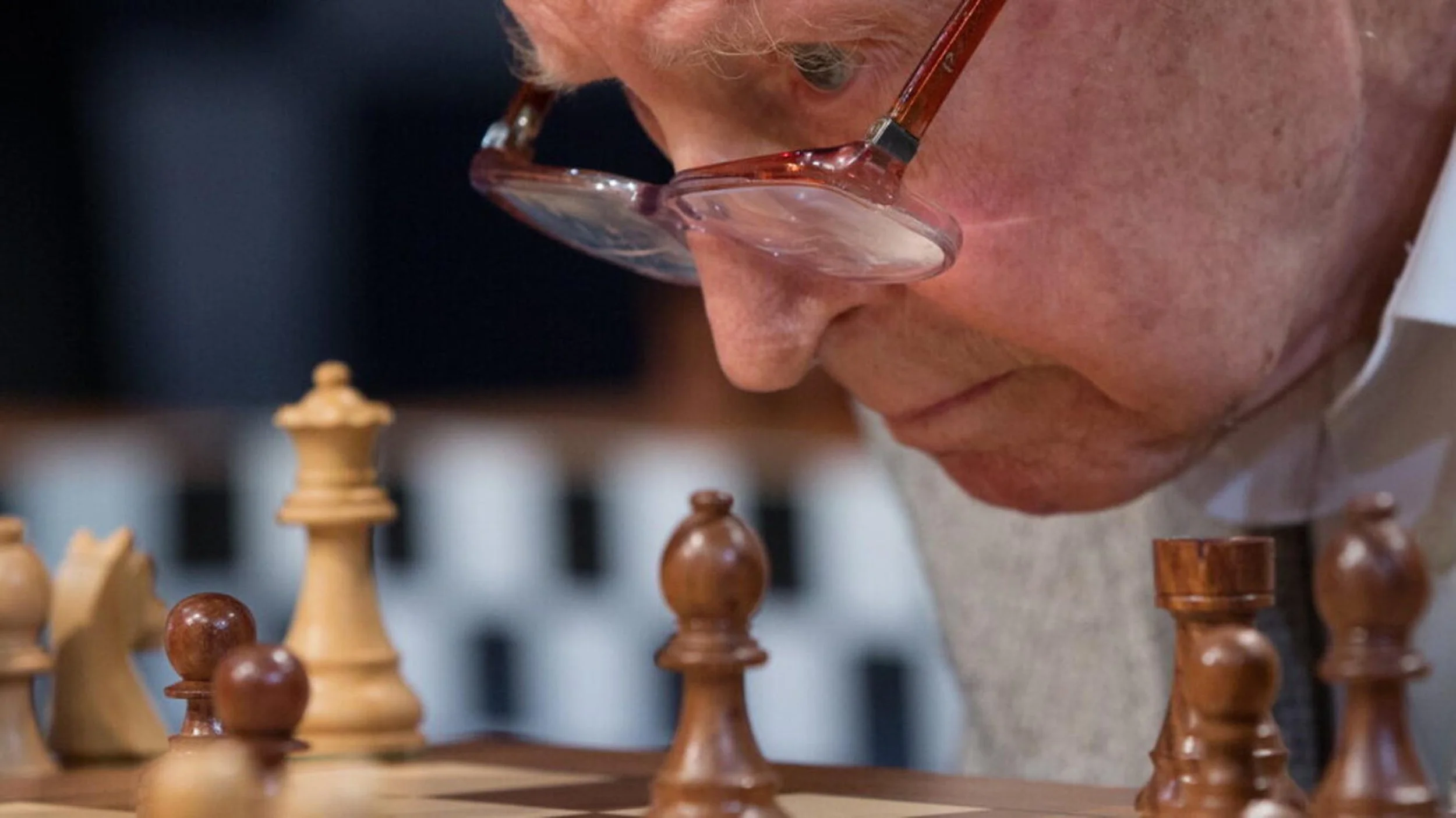 Yuri Averbakh looking at the chess board through his glasses