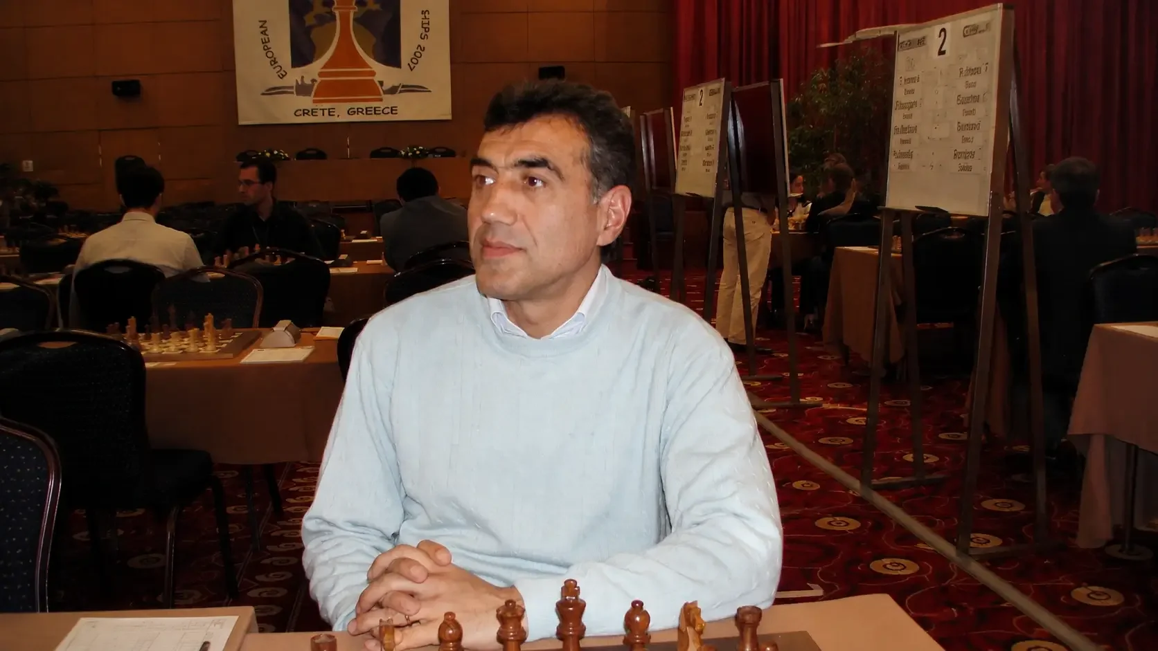 A grandmaster sitting at a chessboard