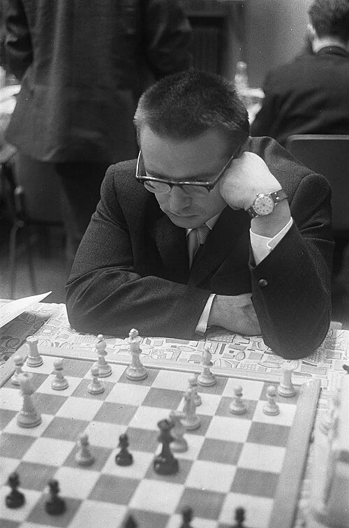 A black and white photo of Lutikov pondering his next move