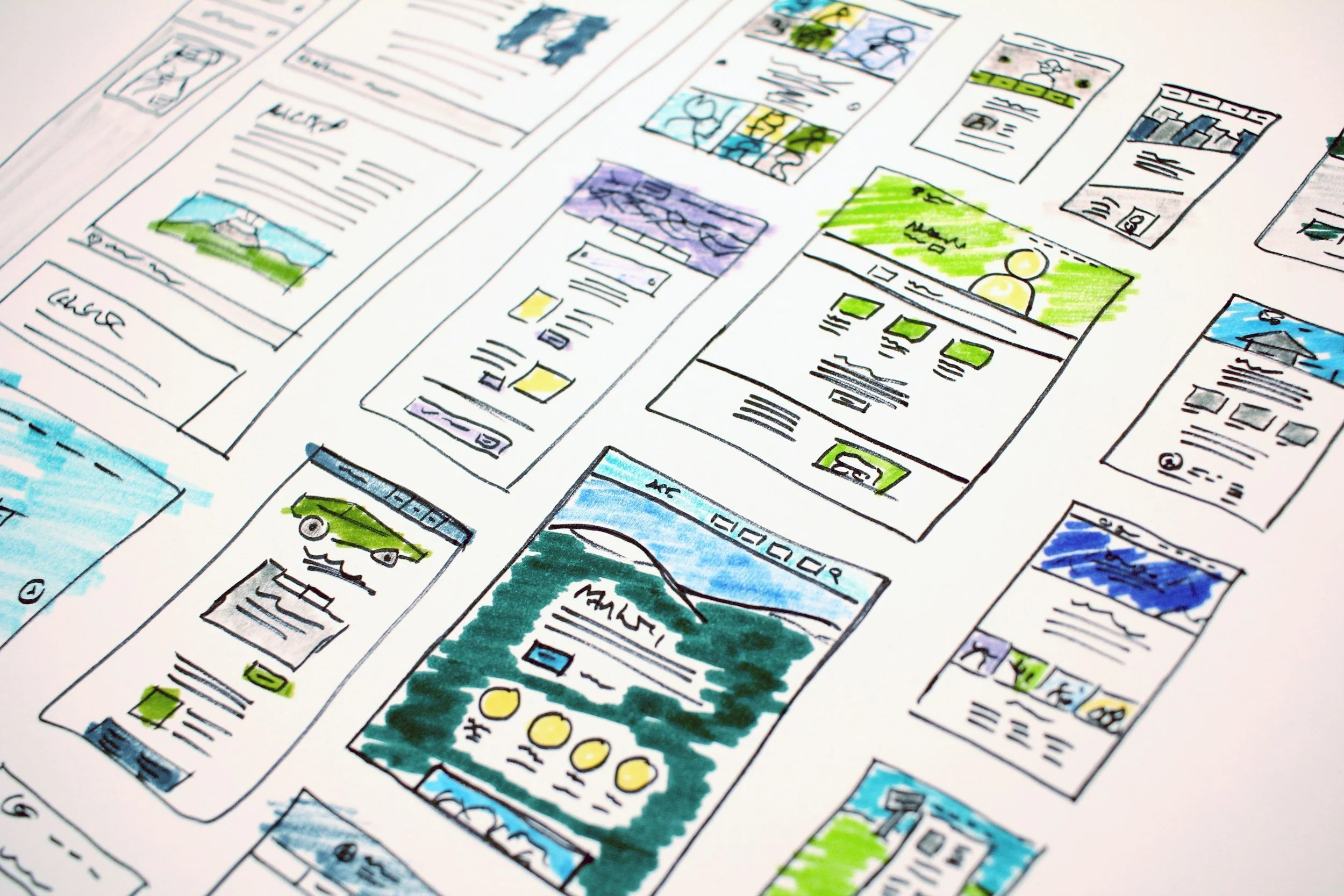 Hand-drawn wireframes and sketches of website or app screens with colorful illustrations and text.