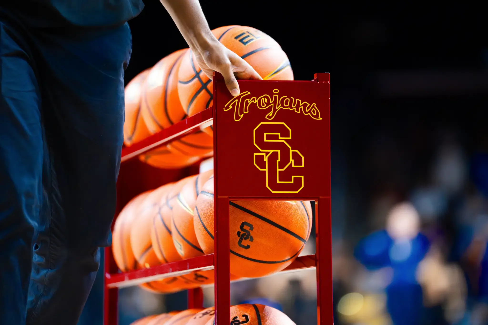 red metal USC Trojans rack, filled with bright orange basketballs with SC imprinted in black