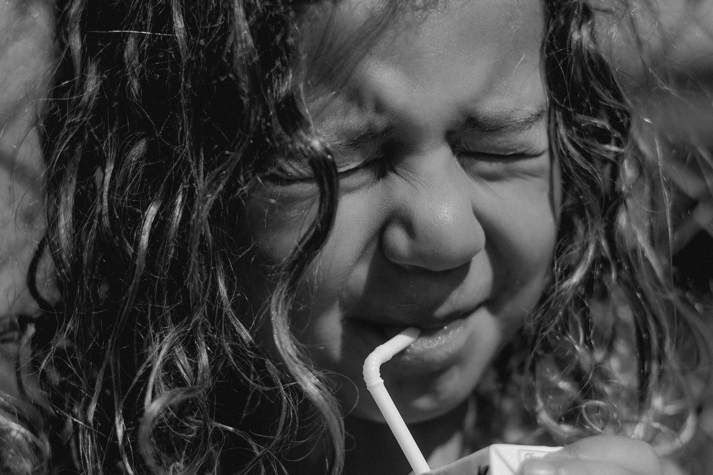 child drinking juice from a straw