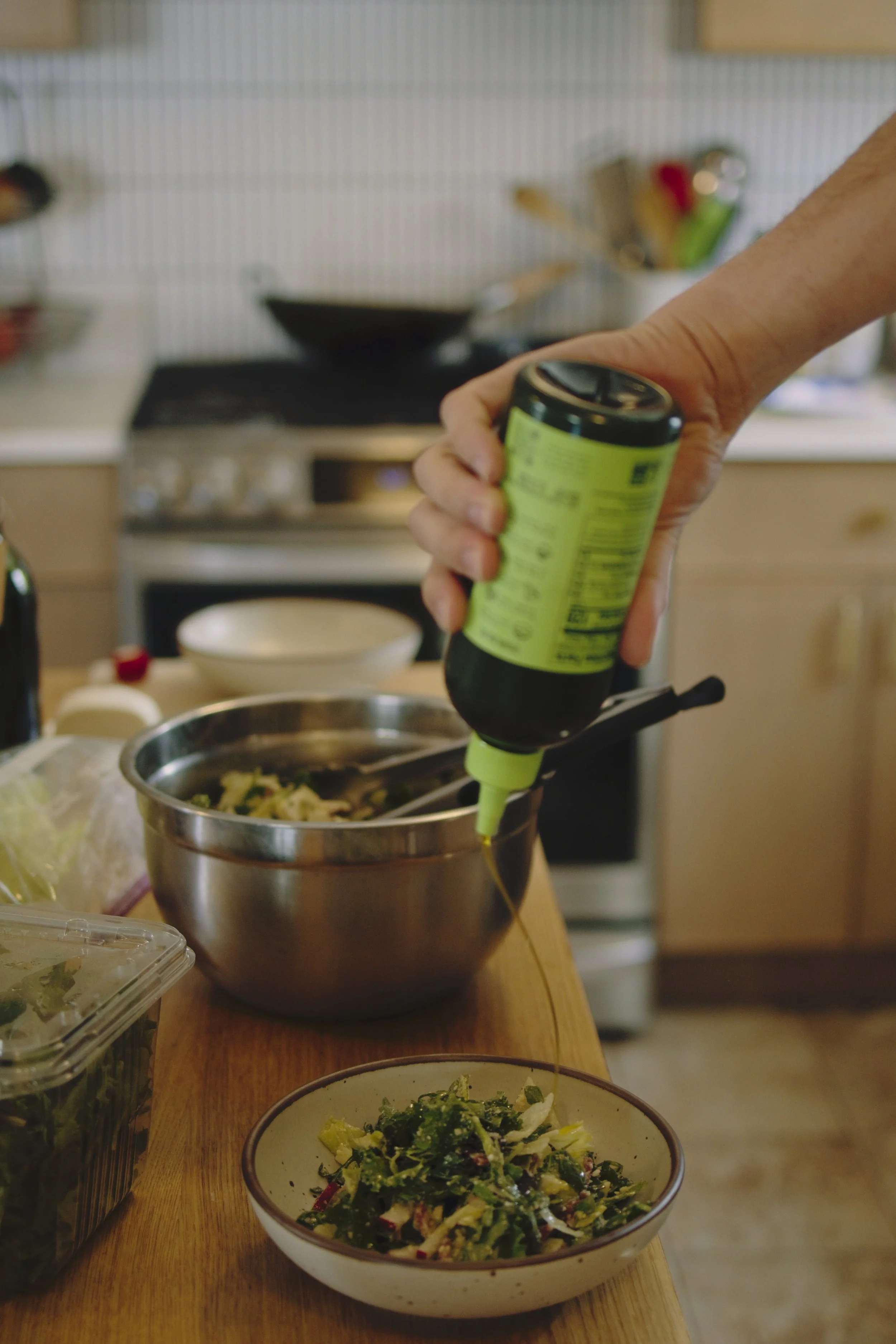 Graza olive oil being poured onto a salad. 