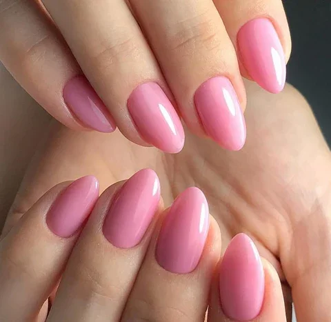 Close-up of a person's painted fingernails with pink nail polish.