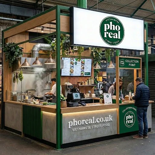 Pho Real Vietnamese street food stall at market, with customers ordering and staff preparing food inside.