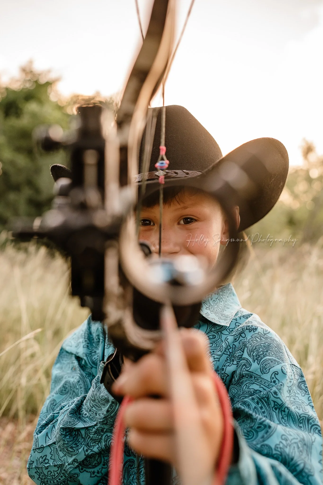 birthday photos of a young boy with a bow captured in Lee County Texas countryside