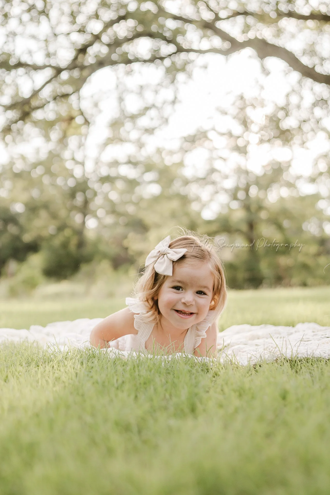 toddler girl surrounded by spring flowers during a 3rd birthday session in Central Texas