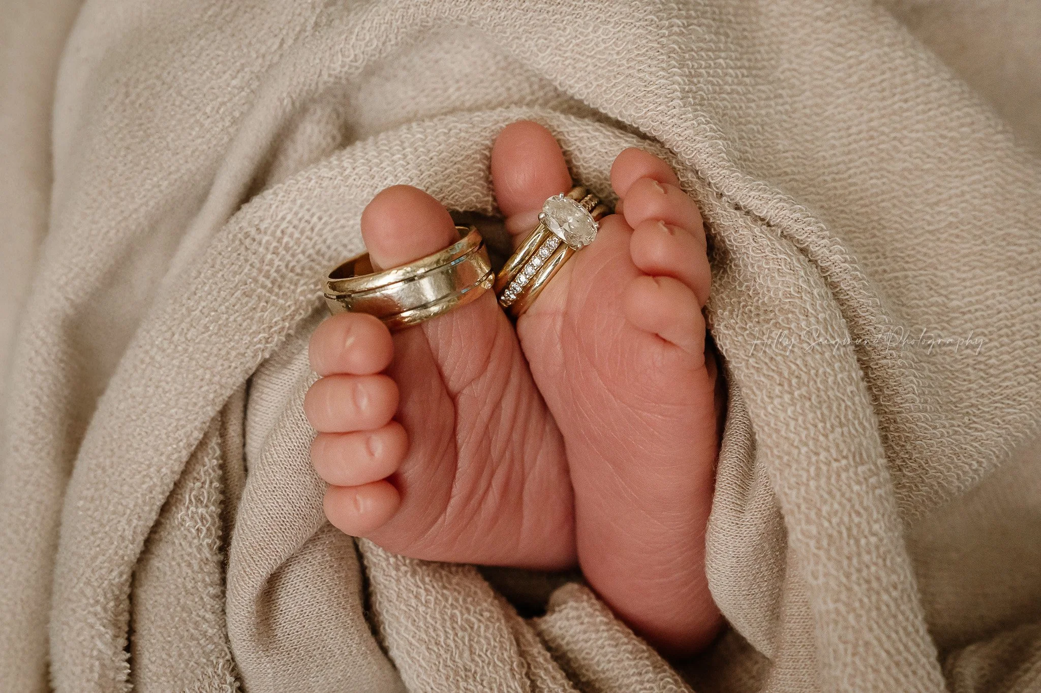 Parent's wedding rings on newborn baby toes
