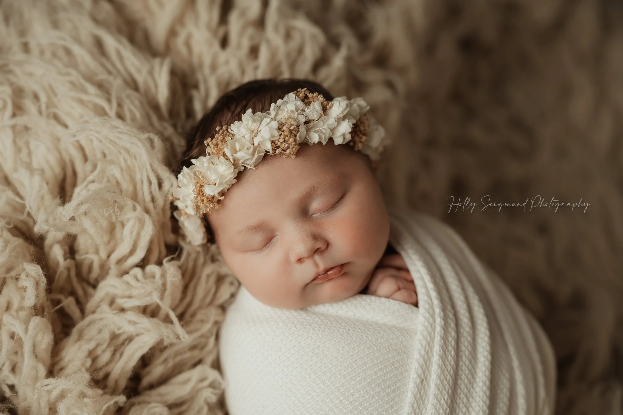 Boho newborn baby girl with a floral crown on a Suede Tan Flokati in a Central Texas newborn studio