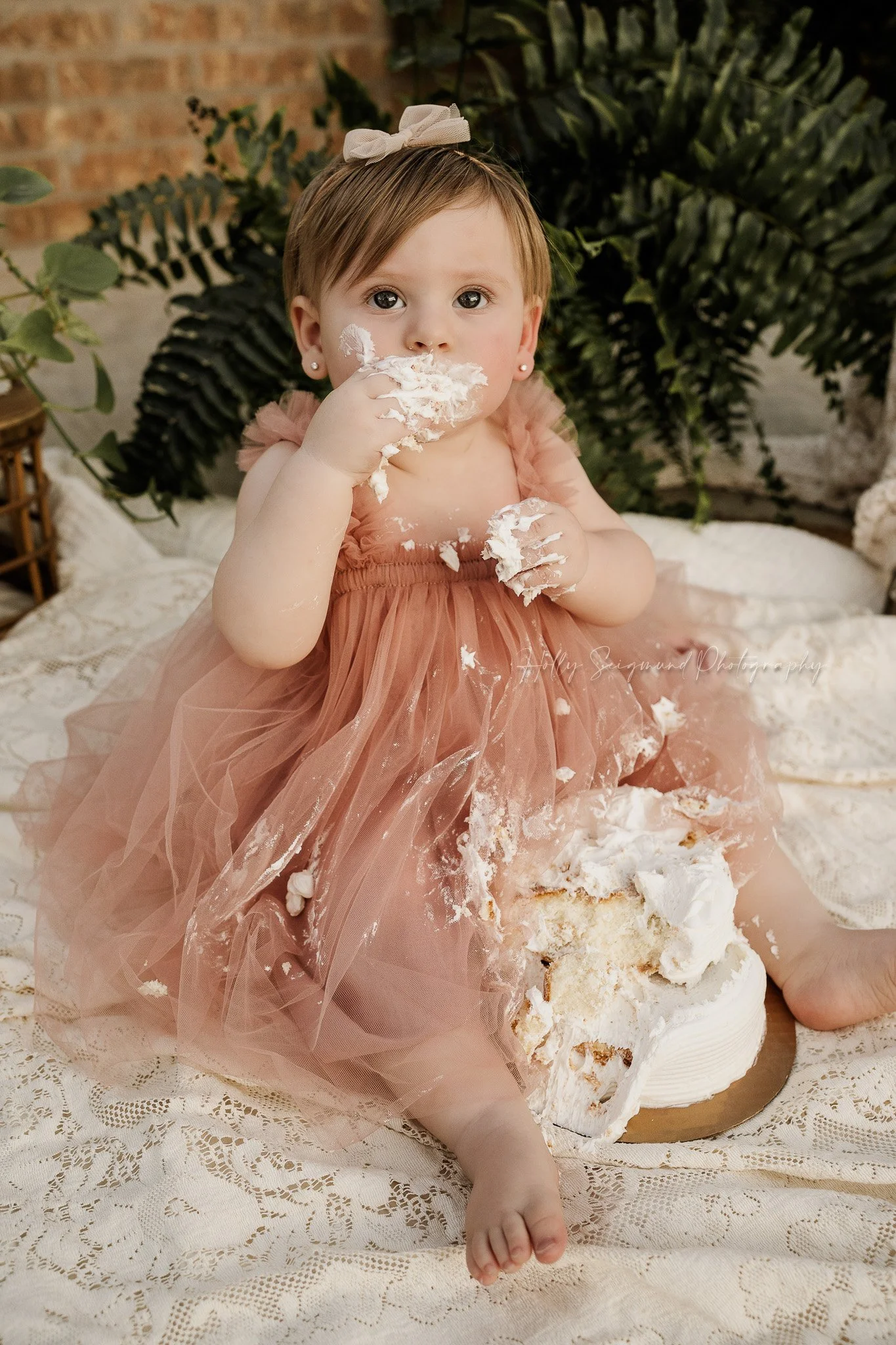 Boho-style first birthday portrait of one-year-old sitting with cake smash near Elgin, Texas