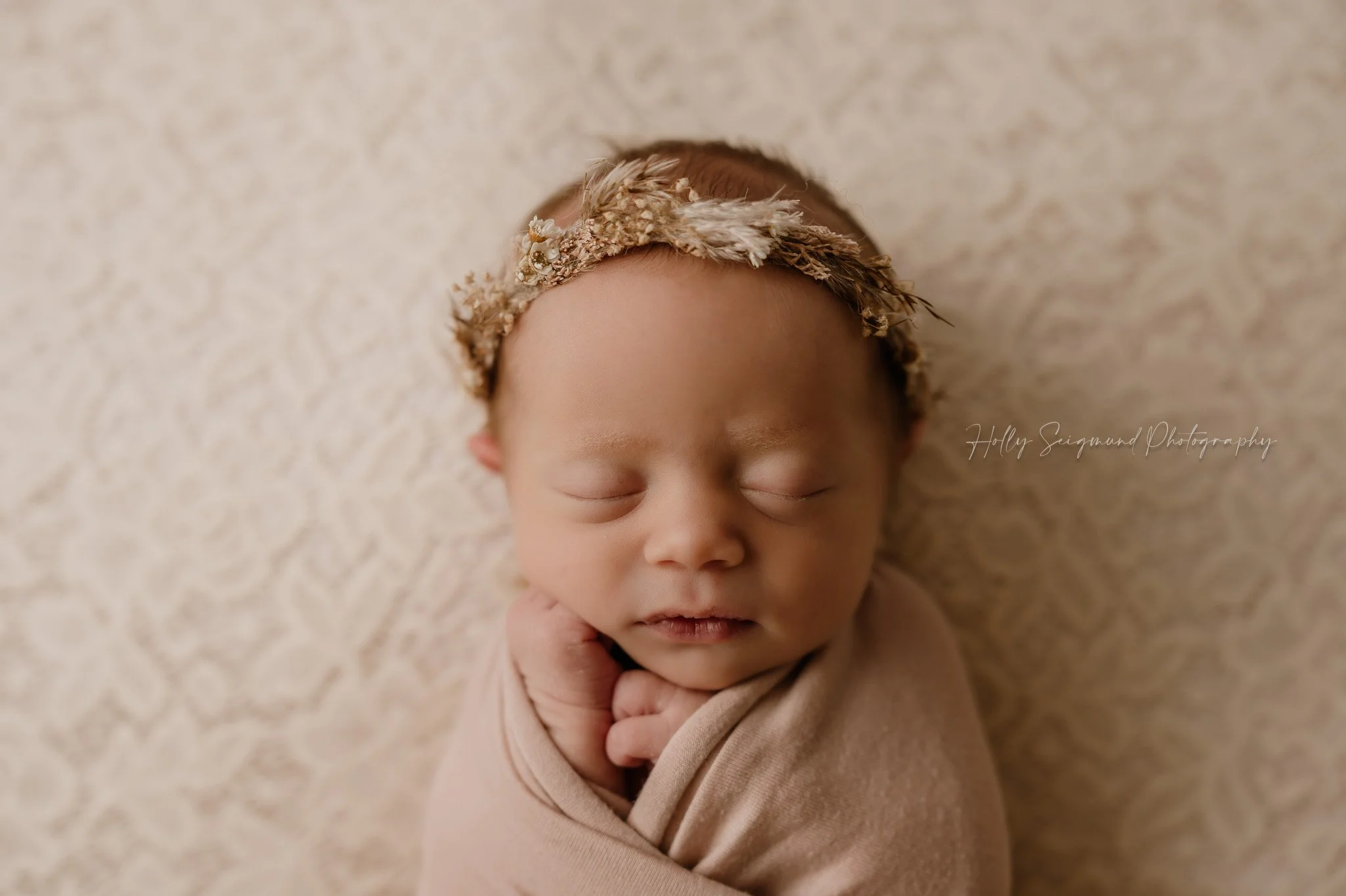 Pink lace backdrop with a newborn wrapped in pink with a floral crown 78947