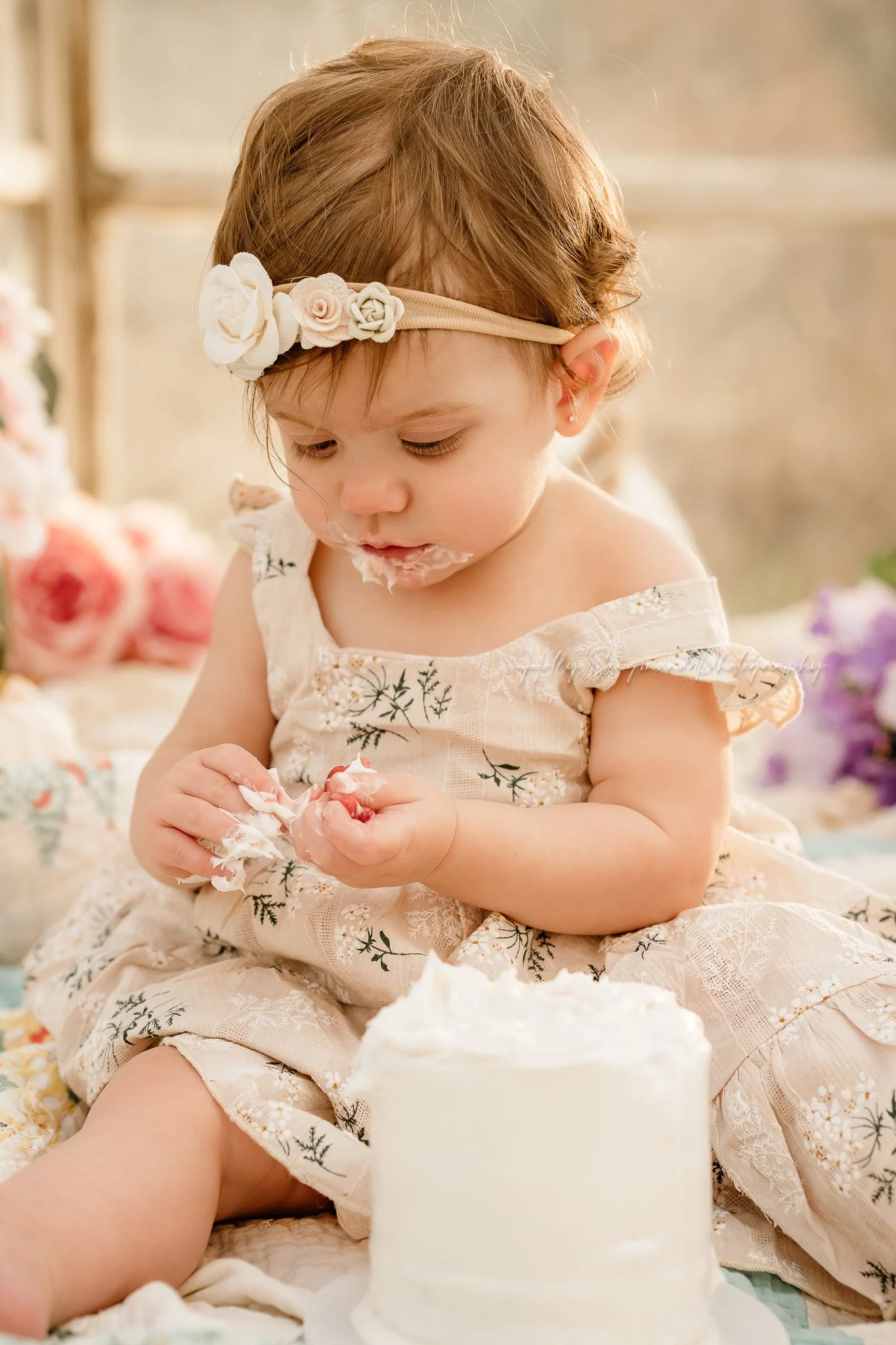 One year old girl smashing her cake during her birthday photos in Central Texas