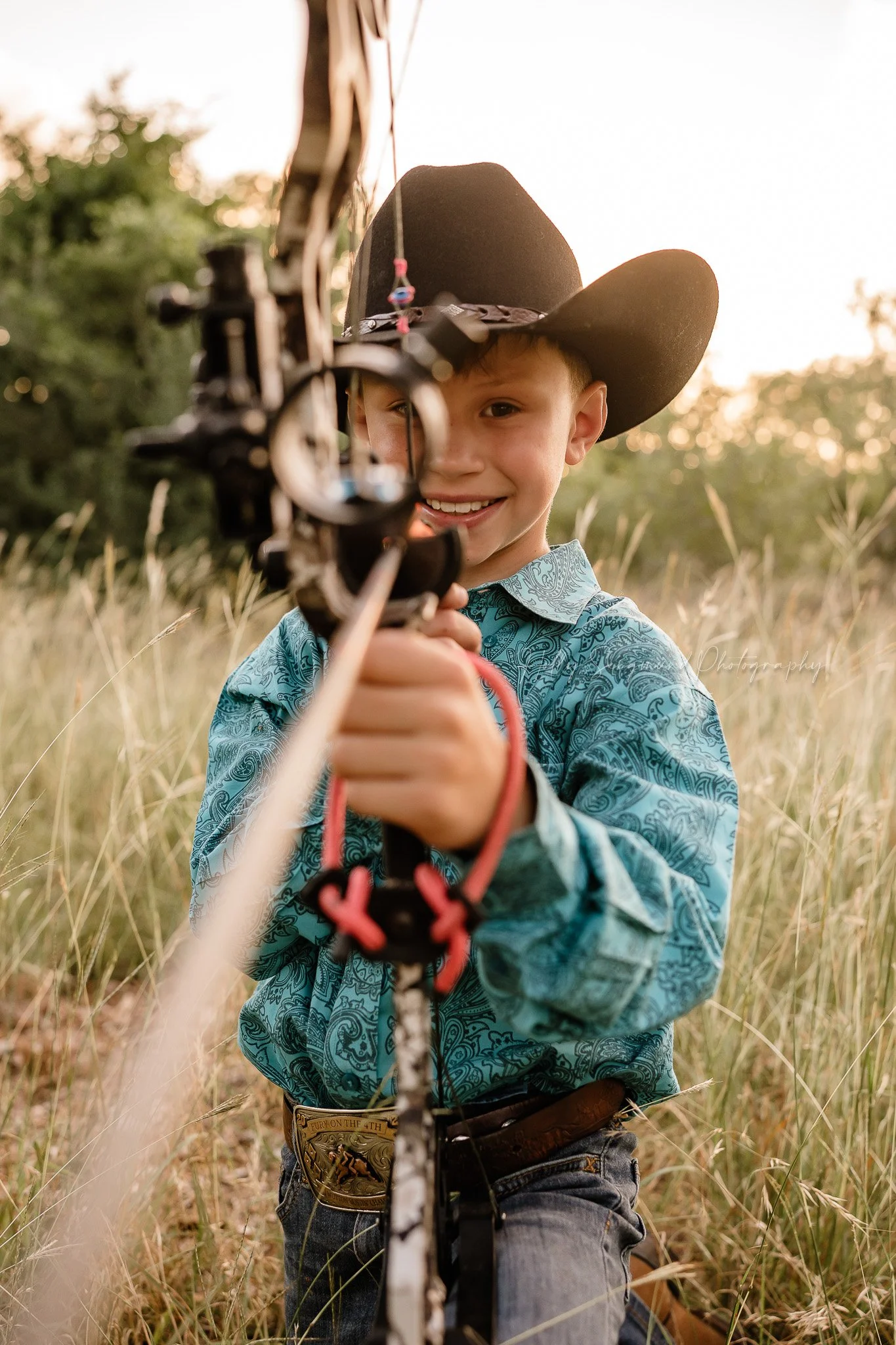 outdoor birthday photos of a boy with a bow in a hunting themed session in Lee County Texas