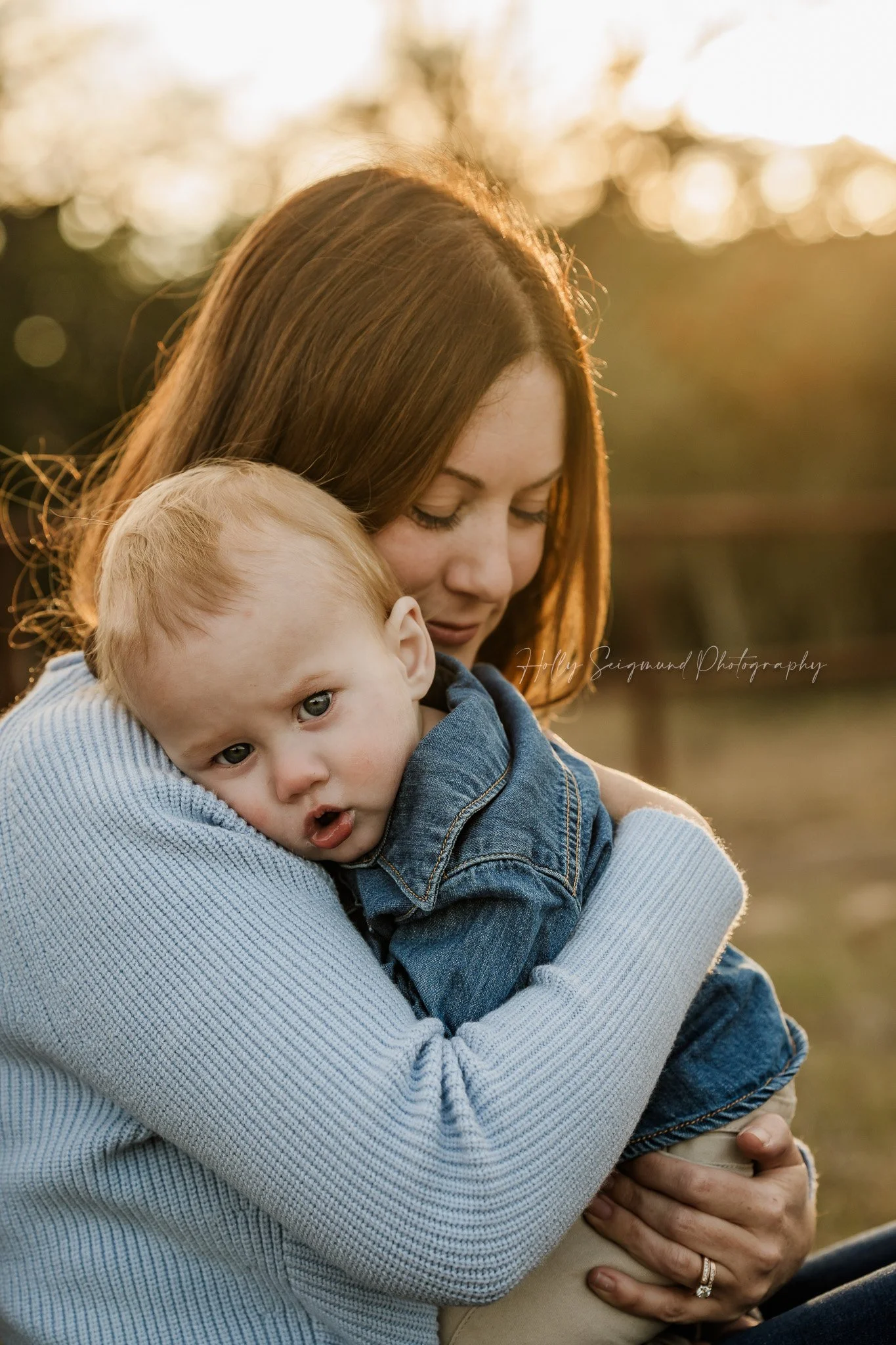 Mom and Son hugs during a first birthday session outdoors in Bastrop County