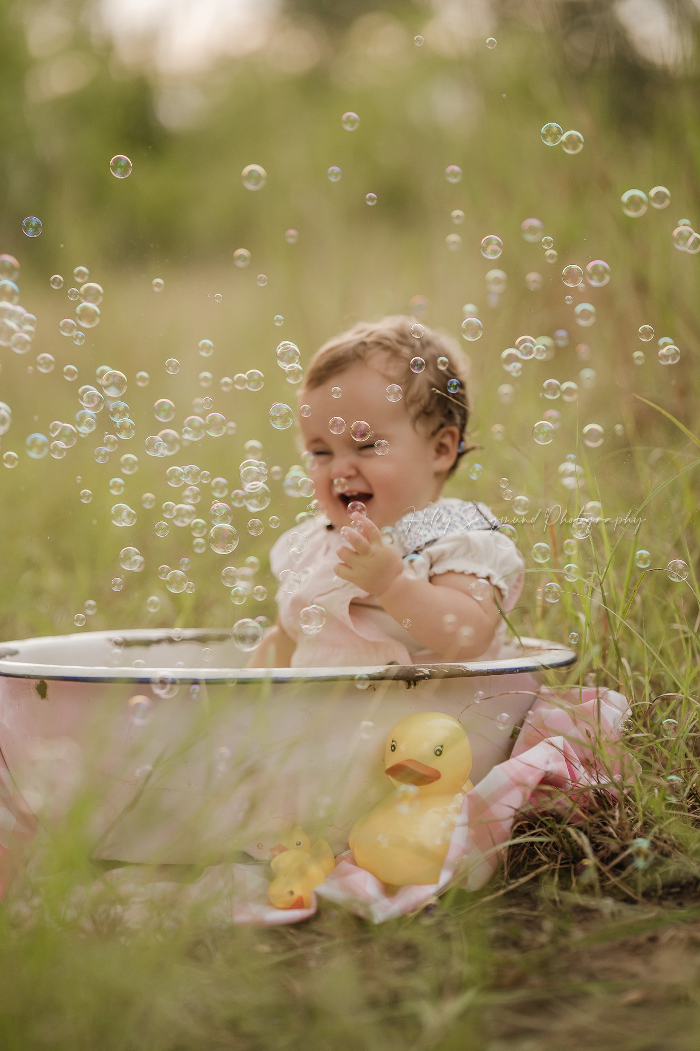 first birthday photos in Central Texas in the spring grass with rubber duckies and bubbles