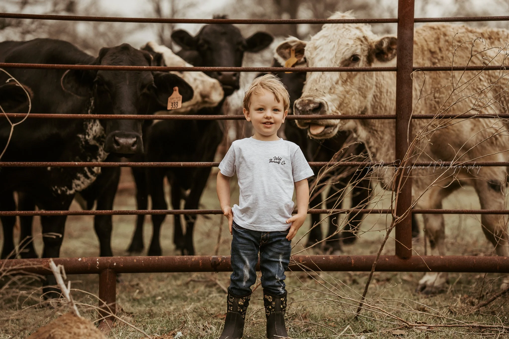 child enjoying a birthday photoshoot outdoors in a Texas country setting with cows