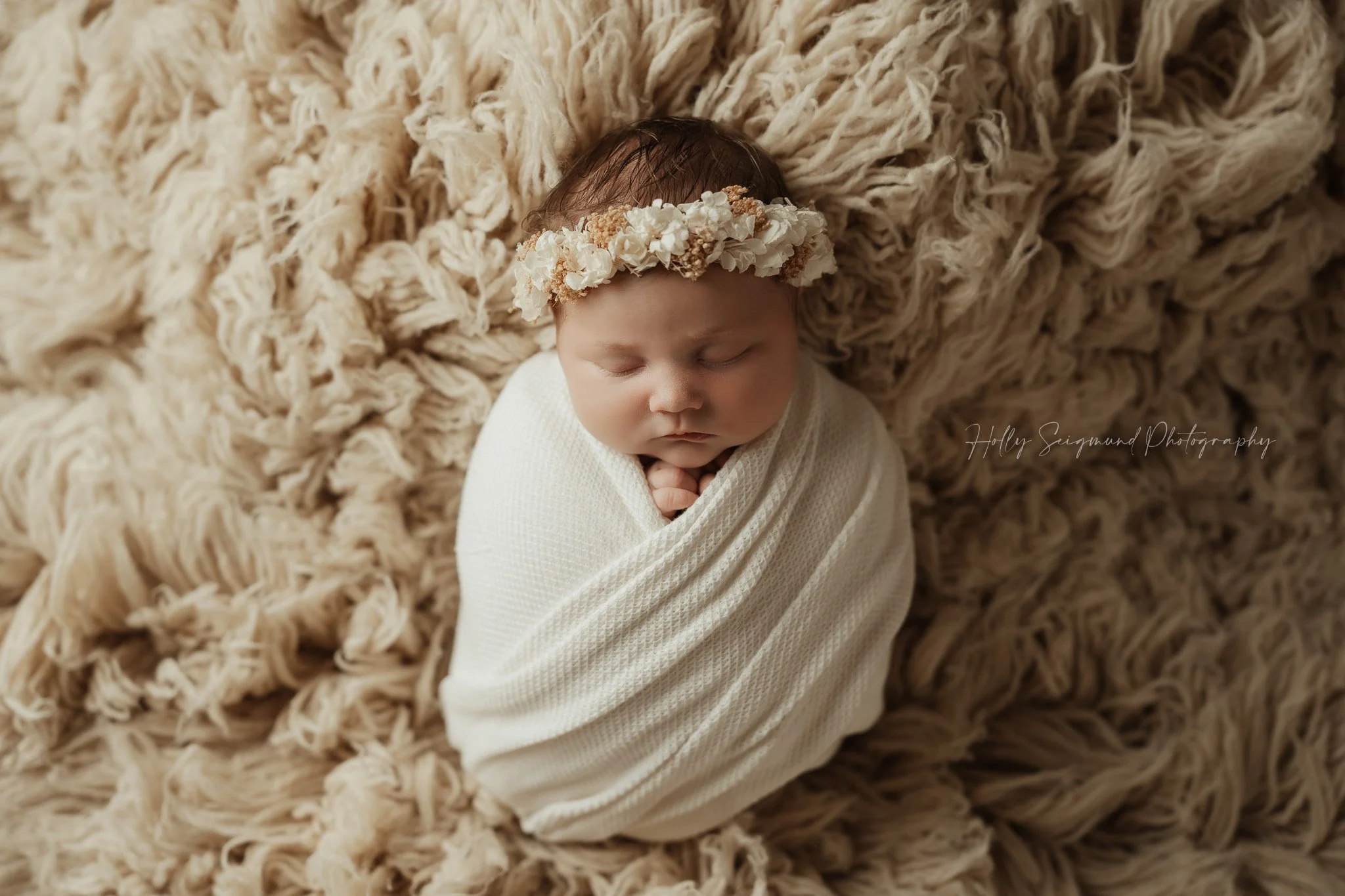 Boho wrapped newborn girl with floral crown on Suede Tan Flokati in Central Texas studio