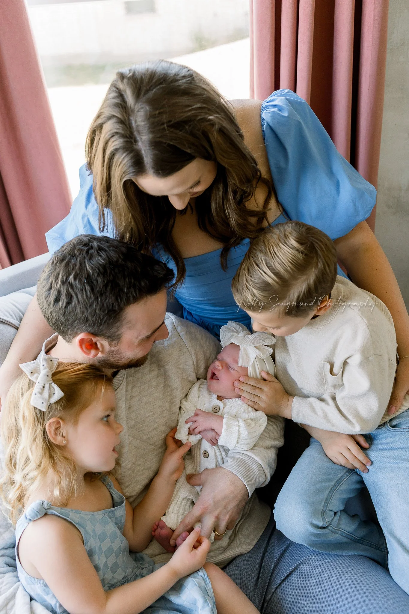 Family cuddling with the new baby in a lifestyle newborn session in Central Texas