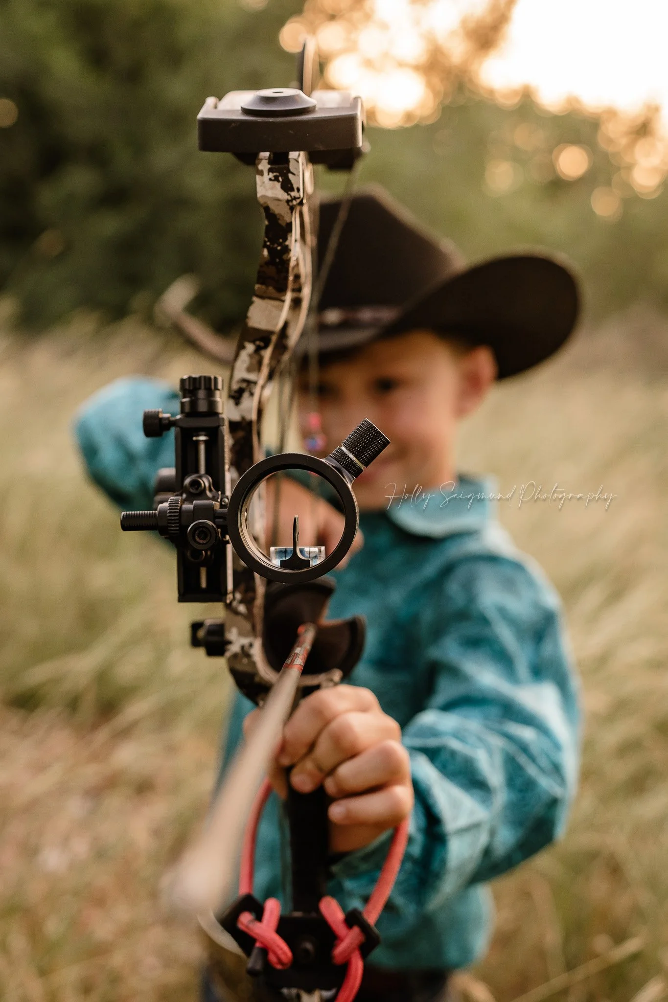 child holding a bow during a hunting themed birthday photoshoot in Lee County Texas