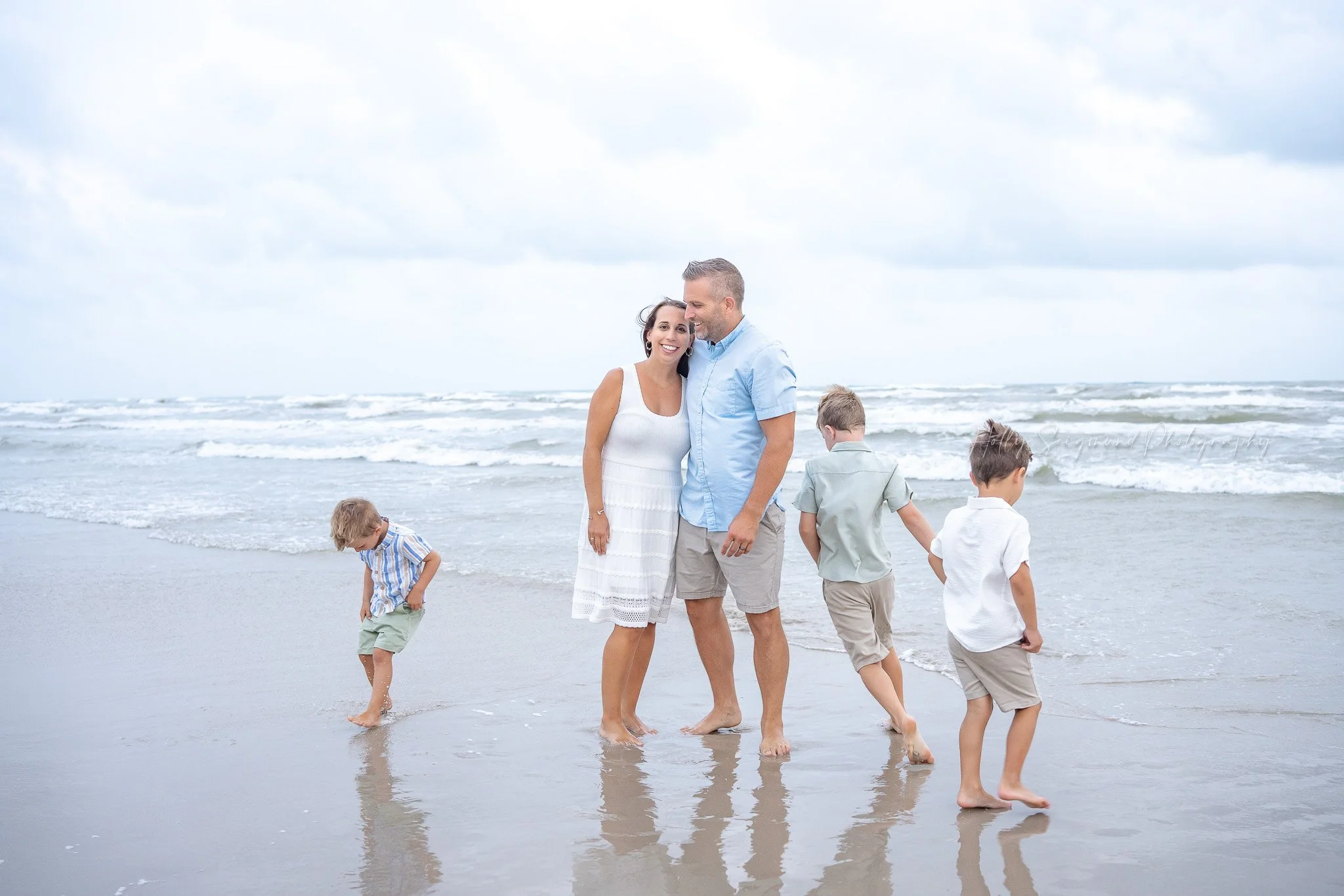 kids running around their parents in the beach surf in port aransas texas