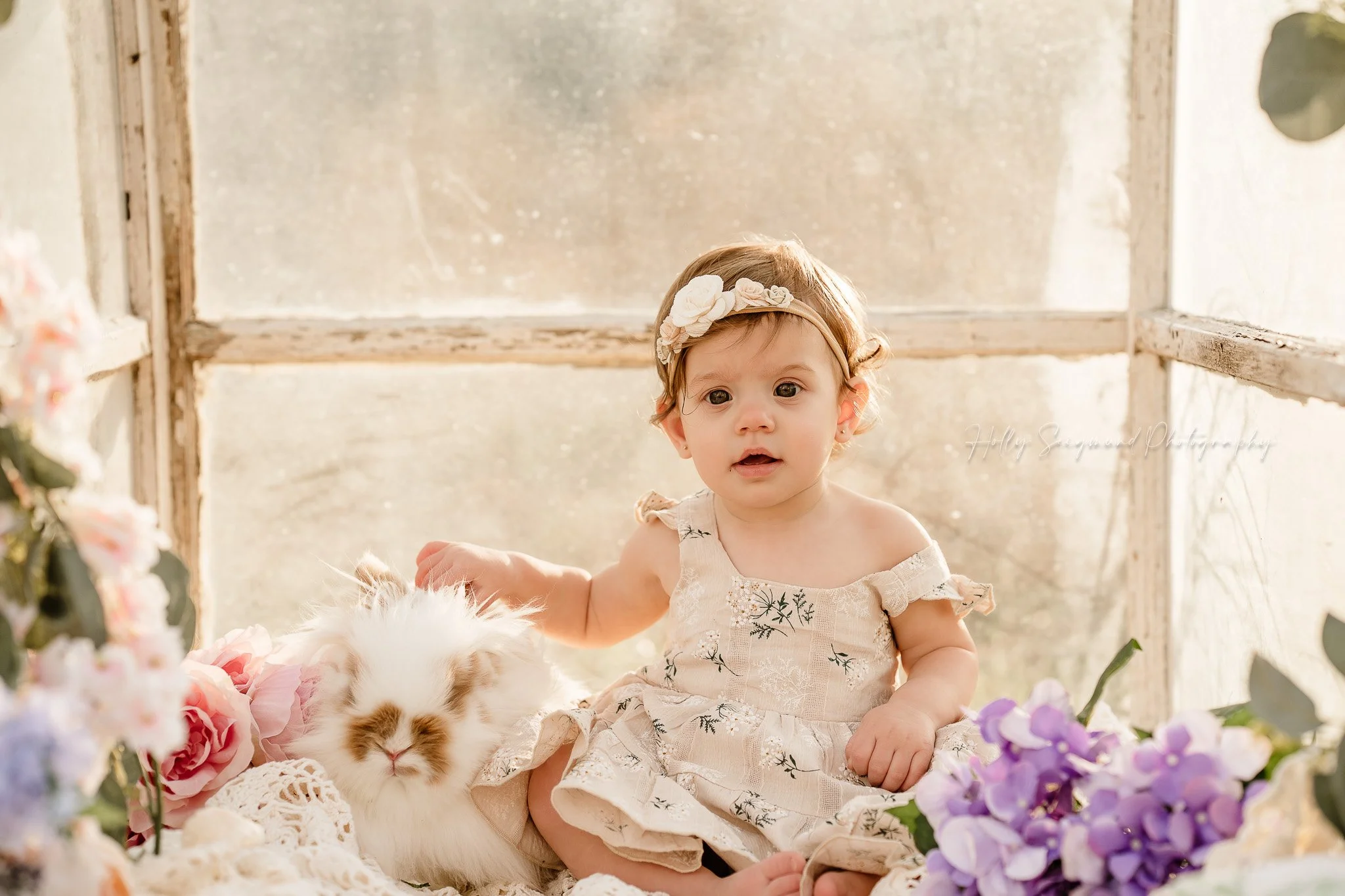 Baby girl and bunny with flowers for first birthday photos near Elgin, Texas