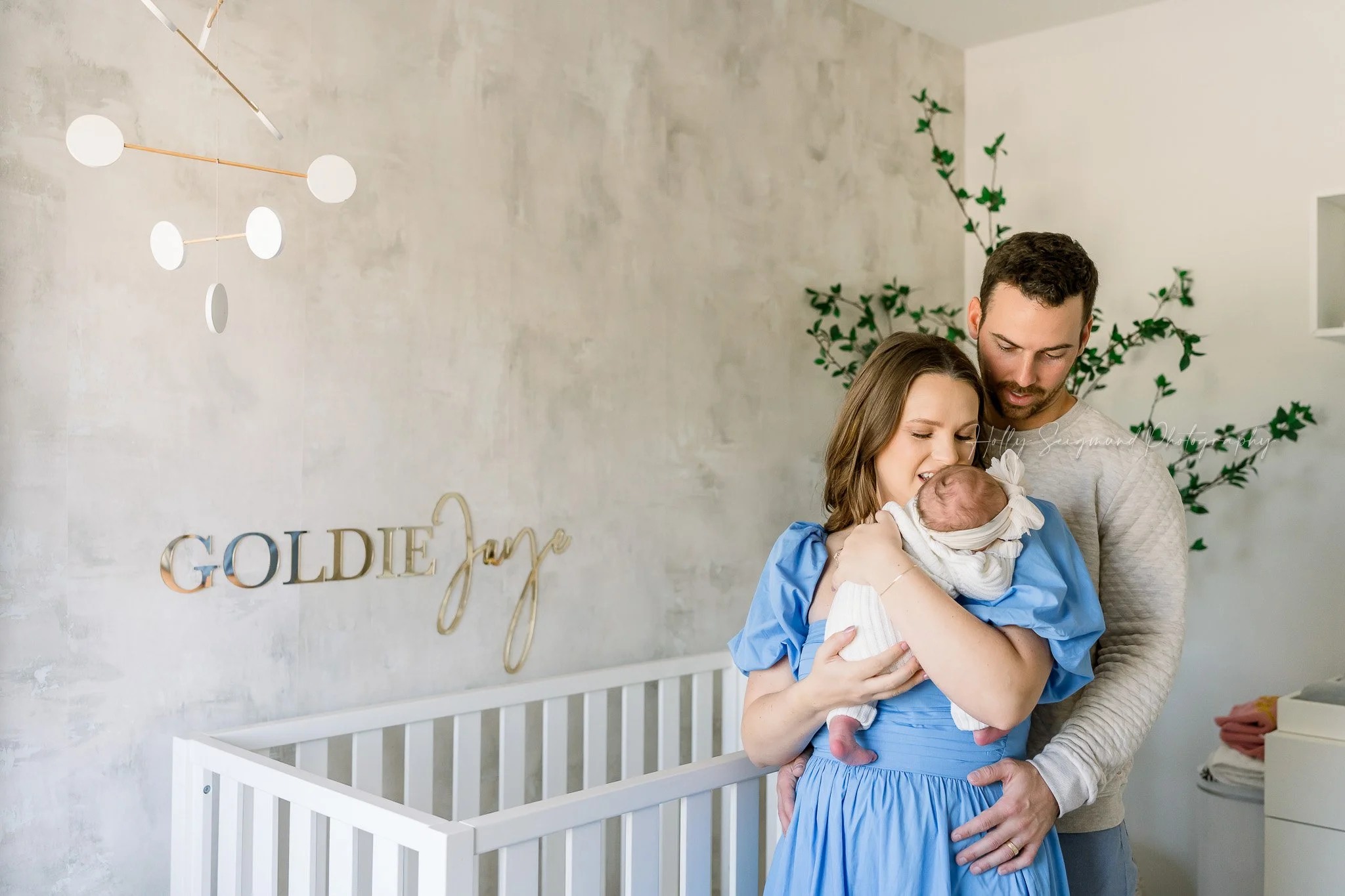 Mom and dad with newborn baby in the nursery during a lifestyle central texas newborn session
