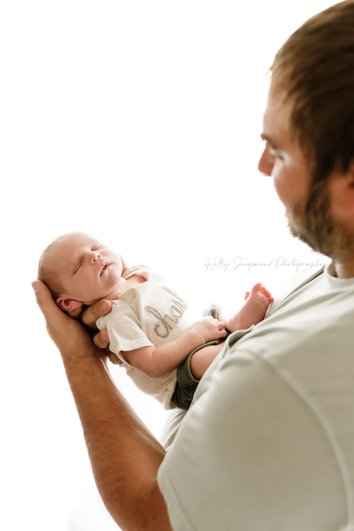 Dad holding newborn baby boy in a natural light studio in Lee County Texas