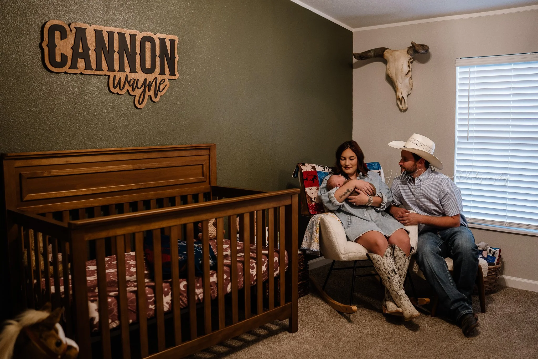 In-home newborn photo with crib and mom and dad in nursery in Central Texas