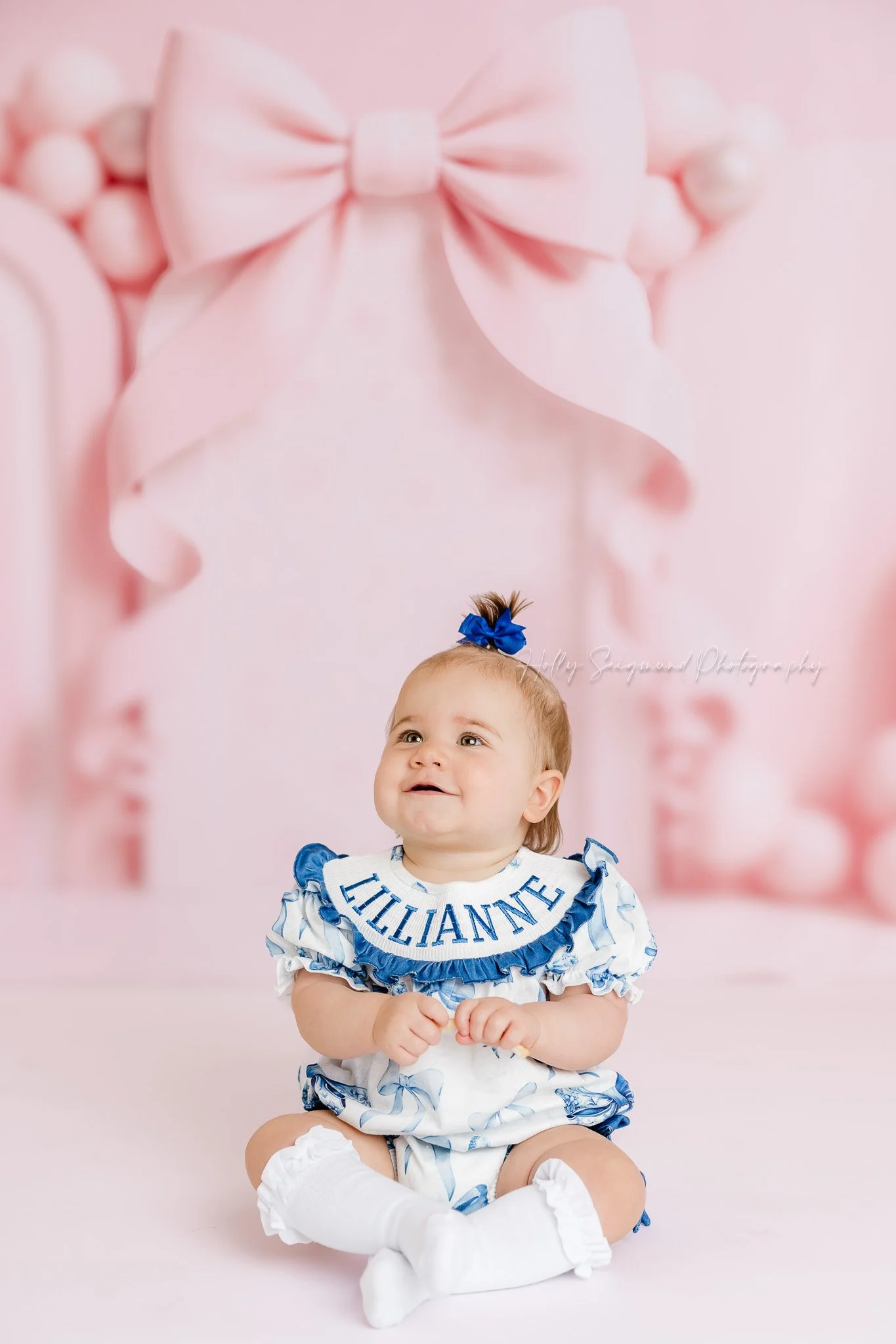 Girls pink bow first birthday photos in studio in Central Texas