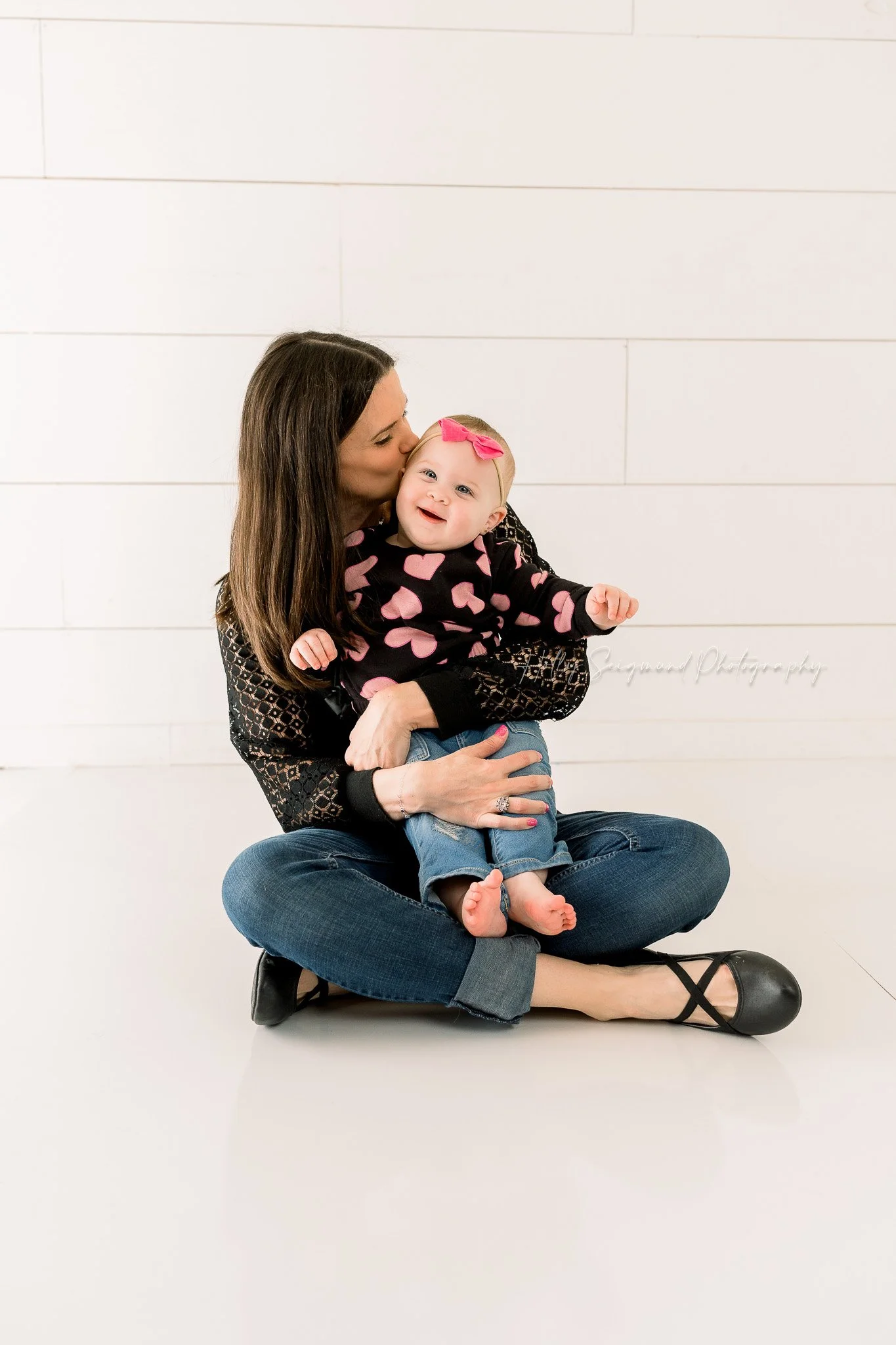 Mom and baby girl snuggling in a natural light studio near Elgin, Texas