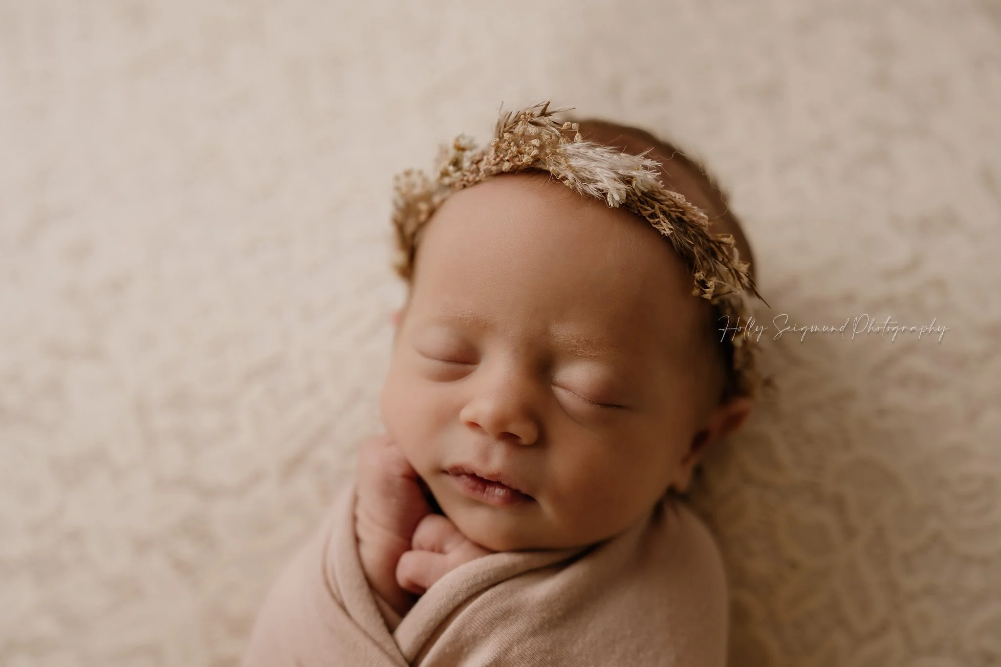 Newborn girl with a floral crown on a lace backdrop in Lee County Texas