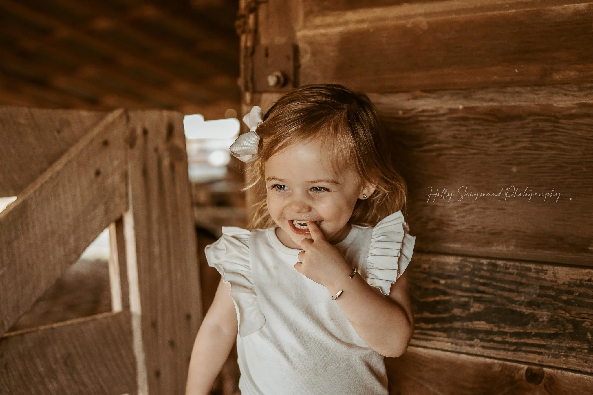young girl photographed in a barn in a natural light country birthday session