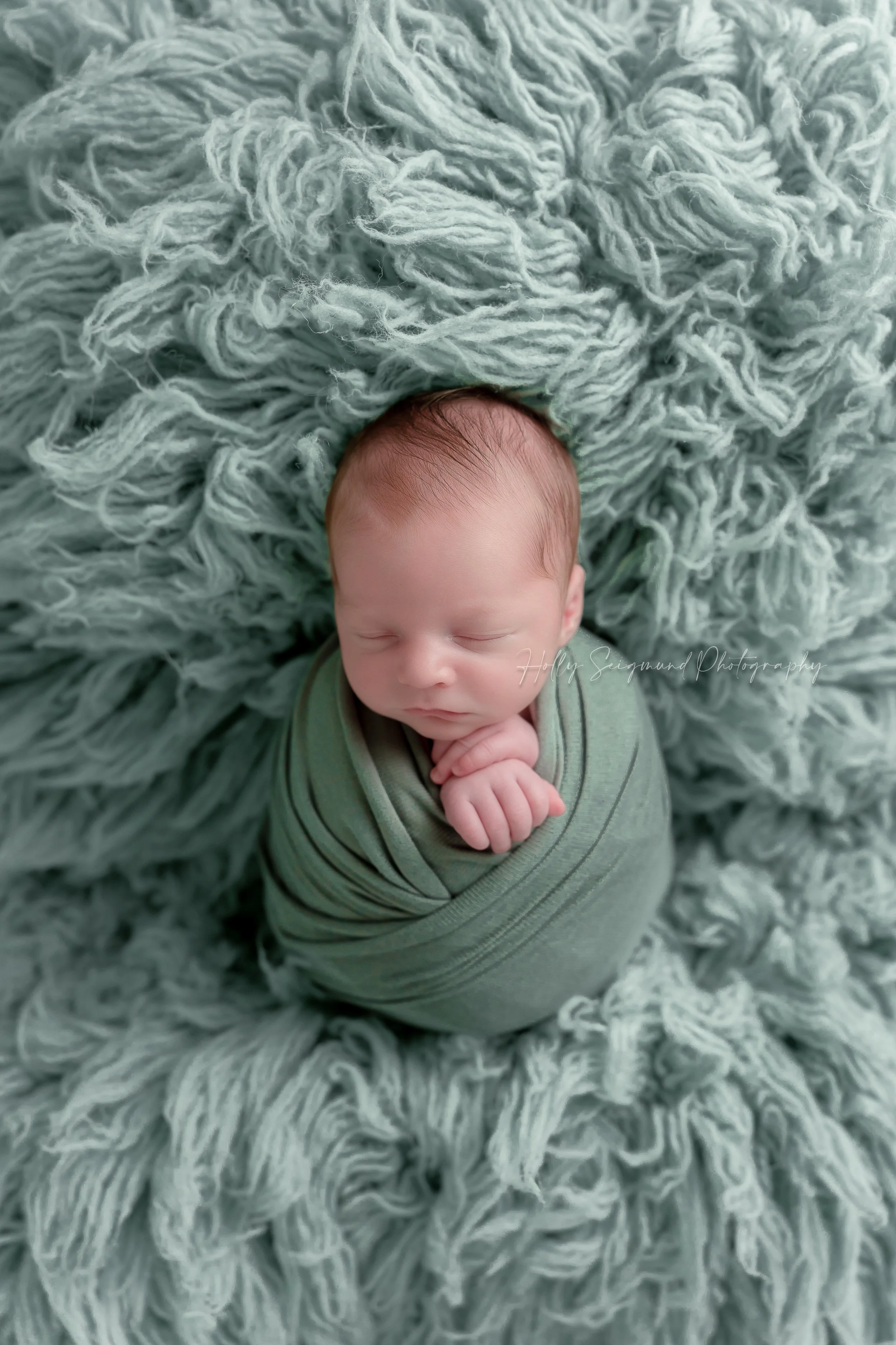 Newborn boy photography session with turquoise wrap and fluffy background in Elgin, Texas