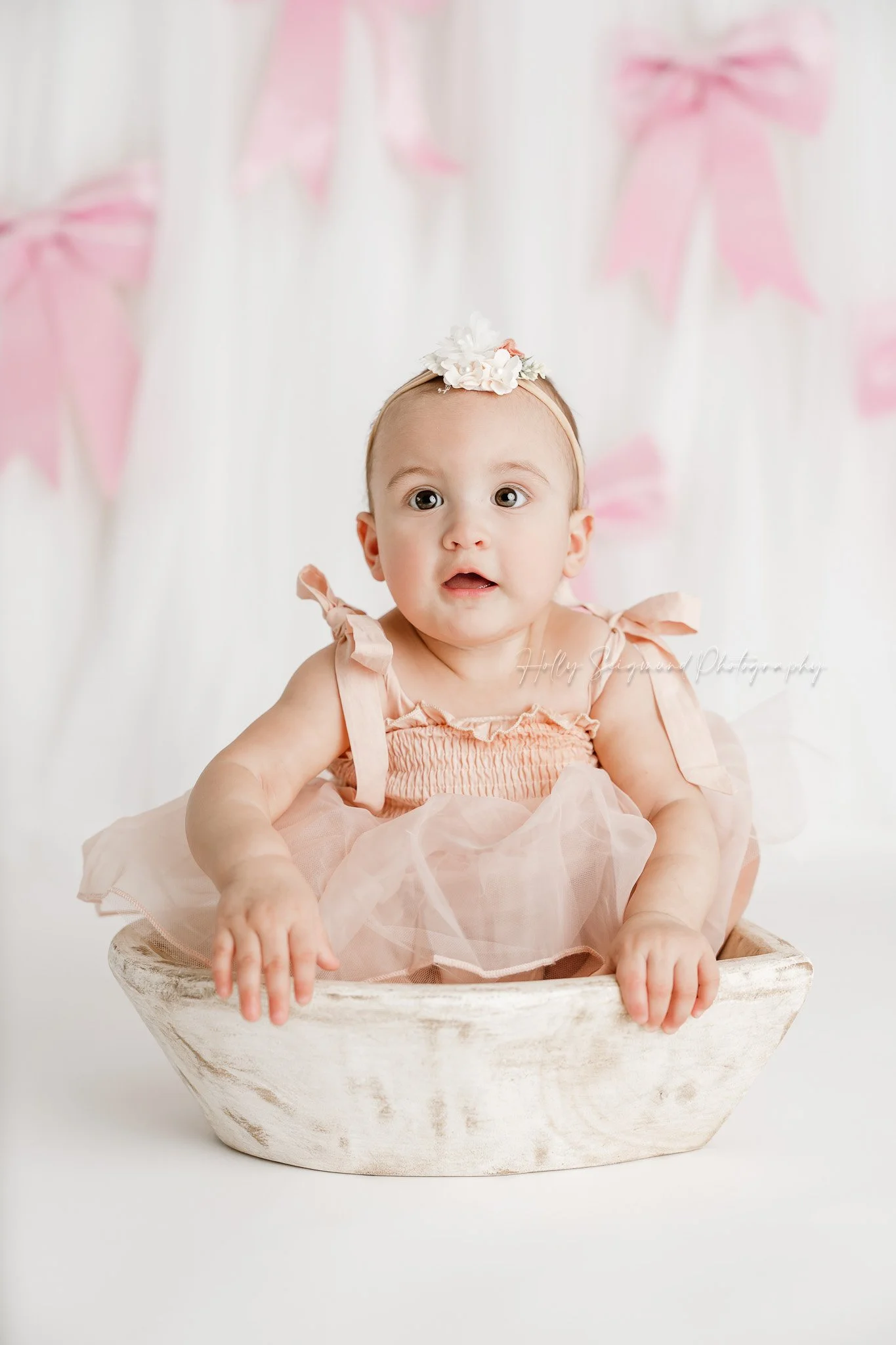 Little girls first birthday session with pink bows in a flash photography studio near Lexington, Texas