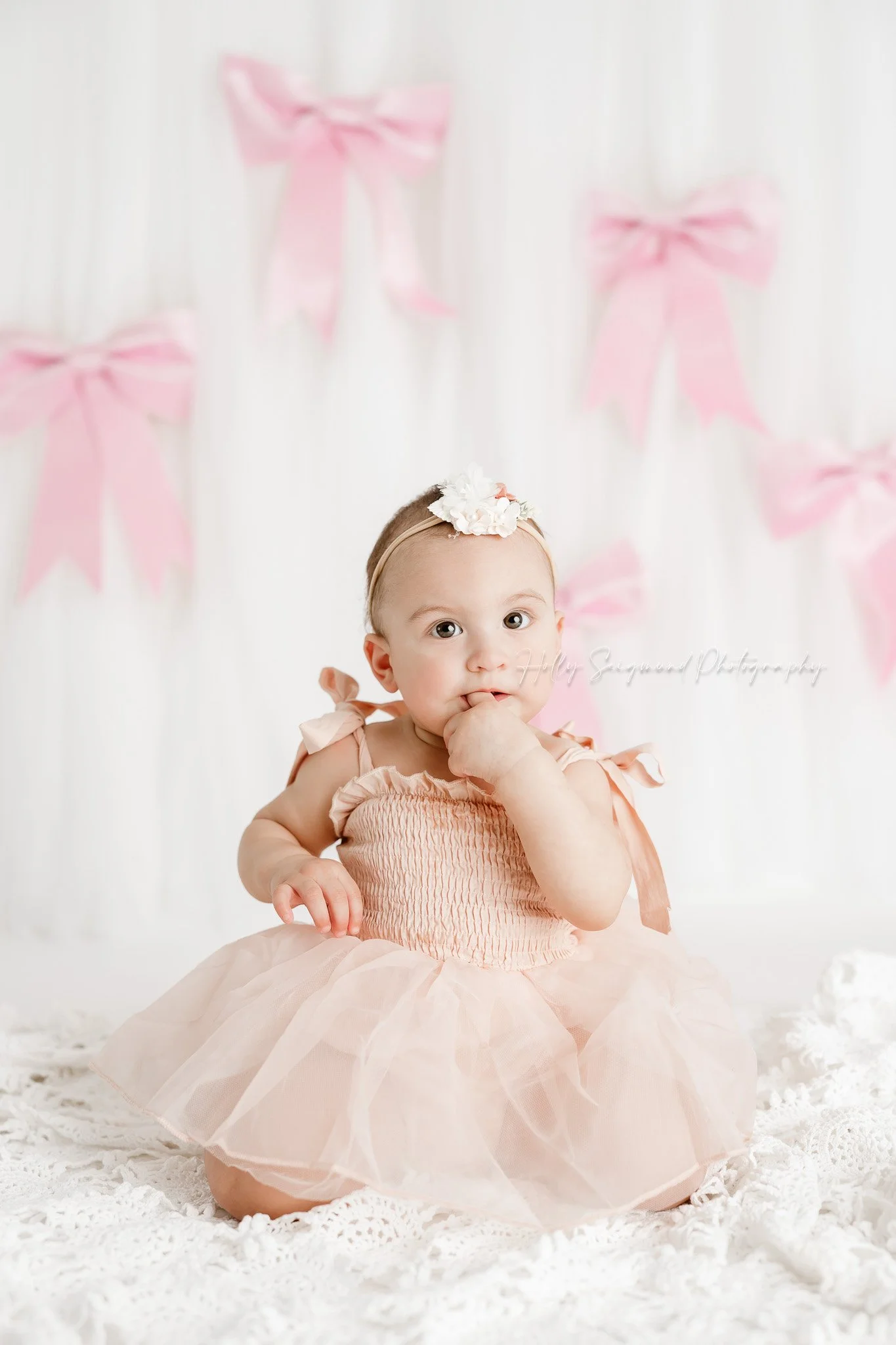Little girls first birthday session with pink bows in a flash photography studio near Elgin, Texas
