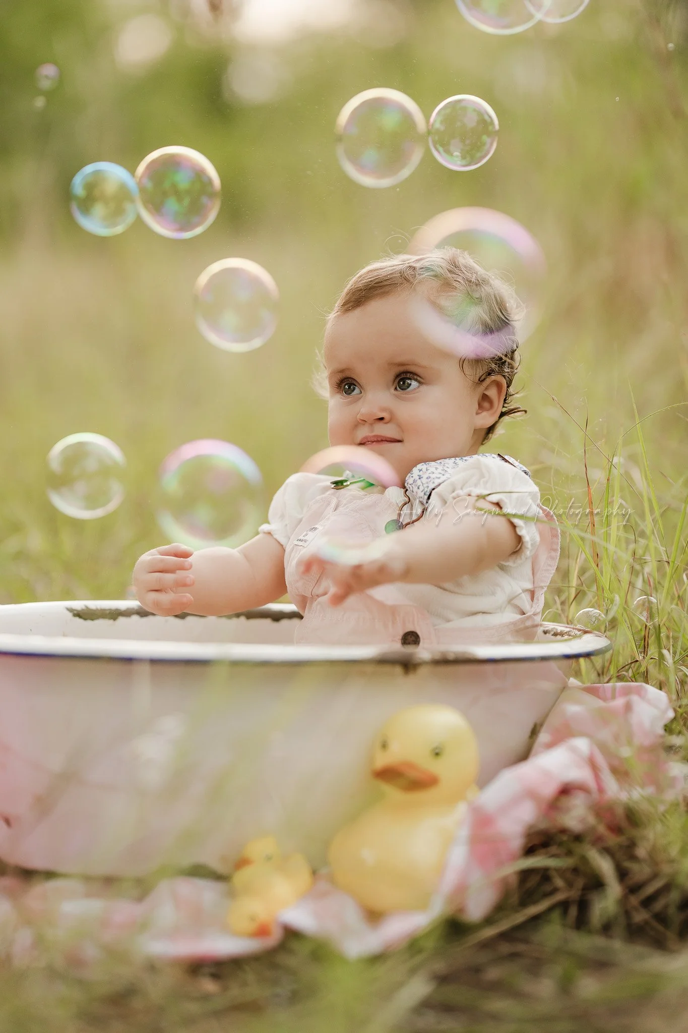 Baby in a bubble bath first birthday photos outside in the grass in Lexington, Texas