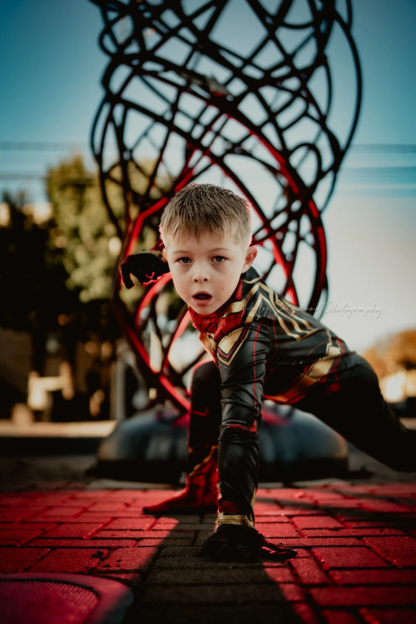 child in superhero costume striking a Spiderman pose during a 6th birthday session in Georgetown TX