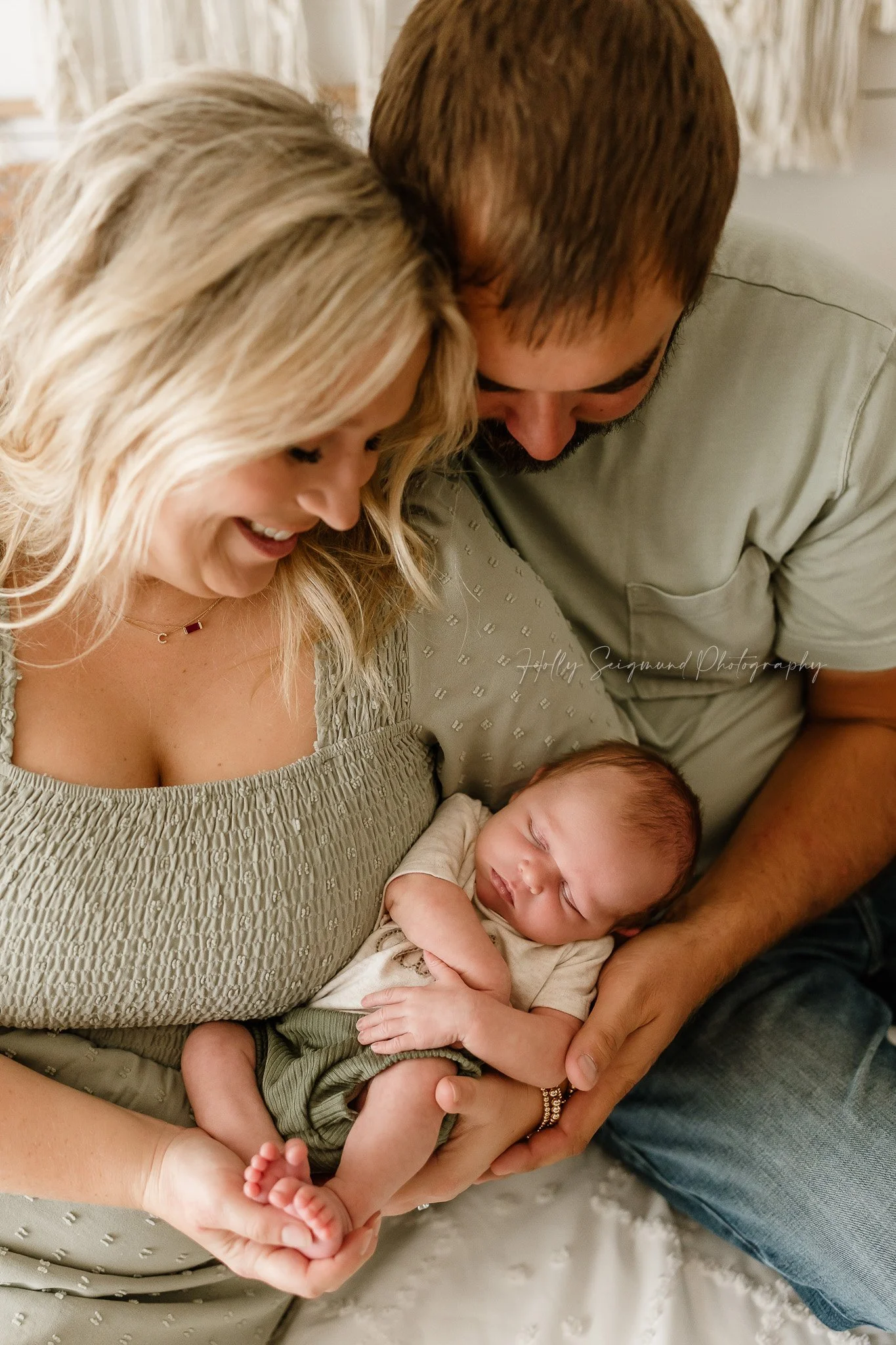 Mom & Dad snuggling baby boy in a natural light photography studio in Lee County Texas