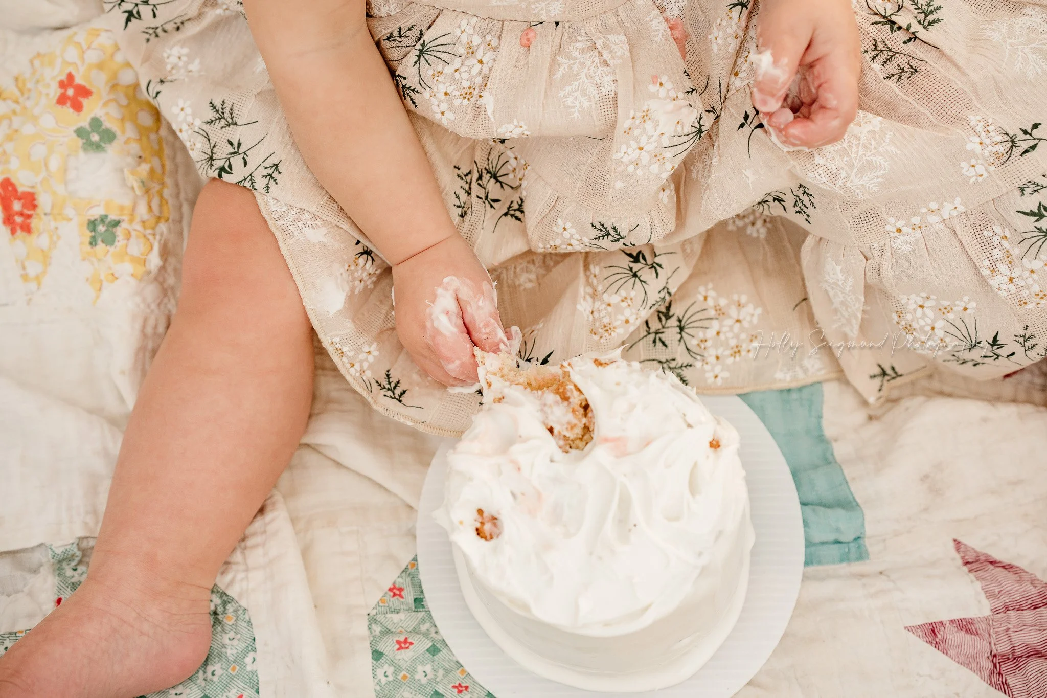 Simple white smash cake on a colorful vintage quilt in Lexington, Texas
