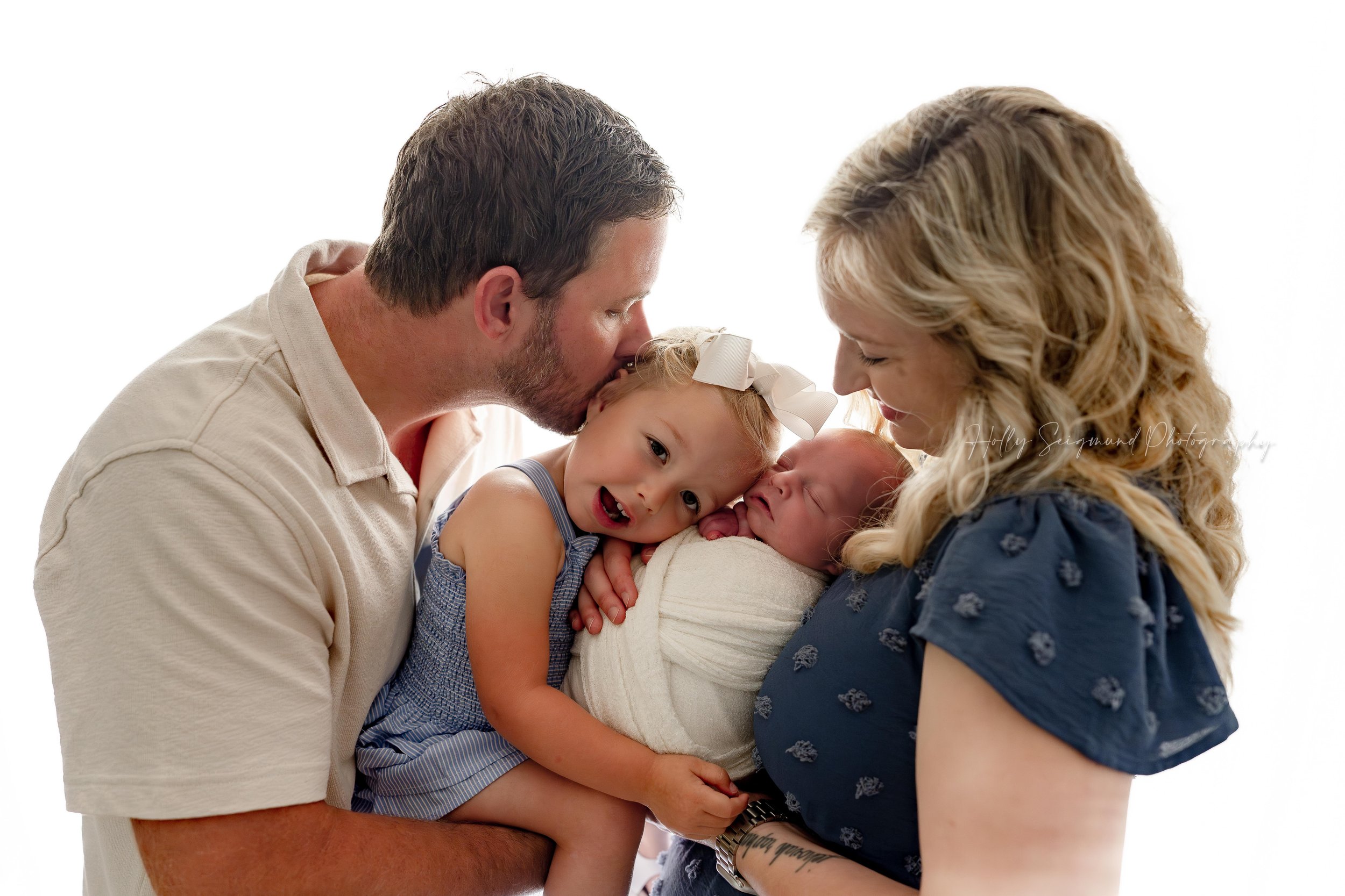 Dad, big sister, baby brother and mom during a family newborn session in studio in Blue, Texas