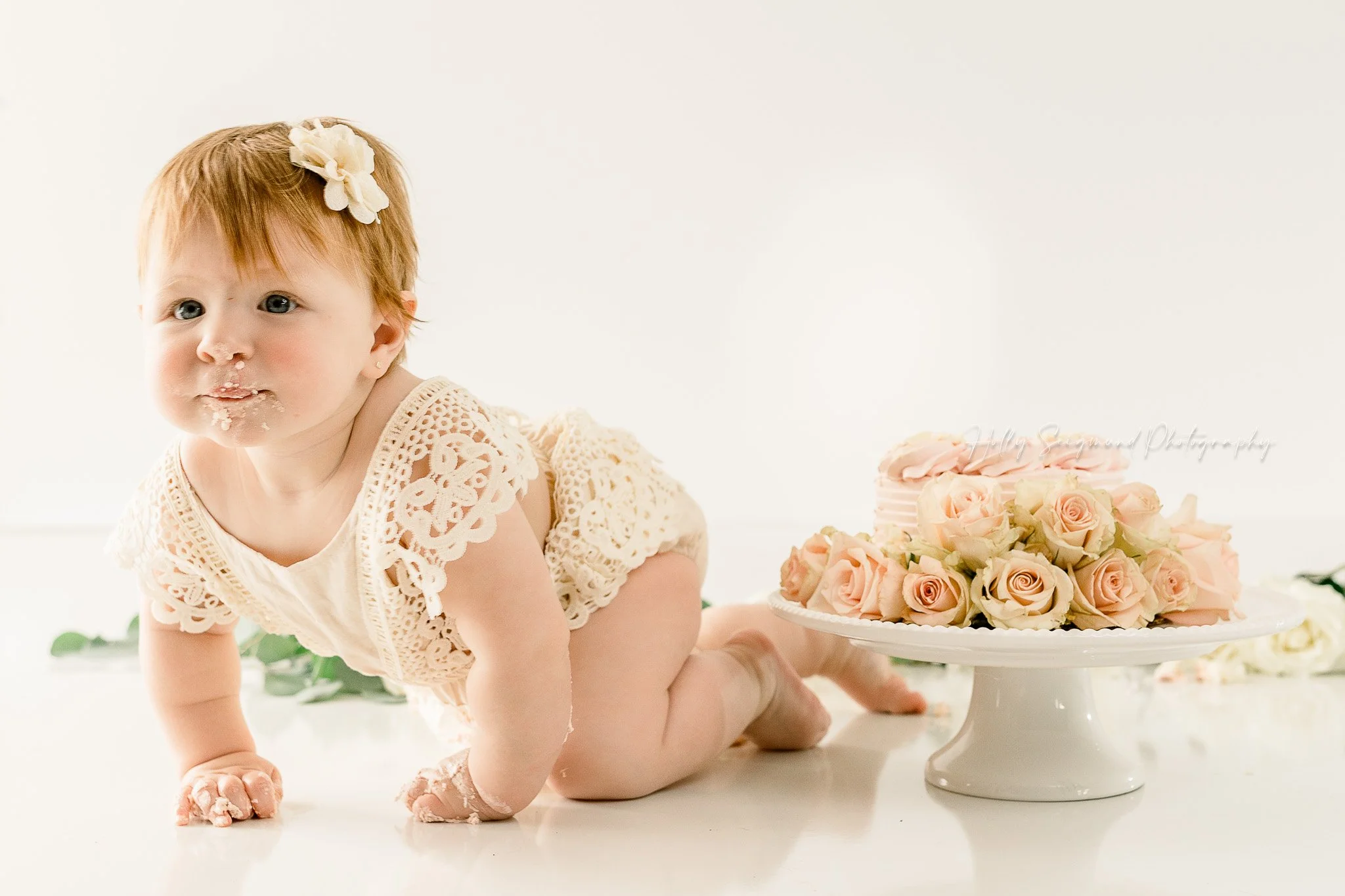 simple white backdrop with florals smash cake session in a natural light studio in 78947