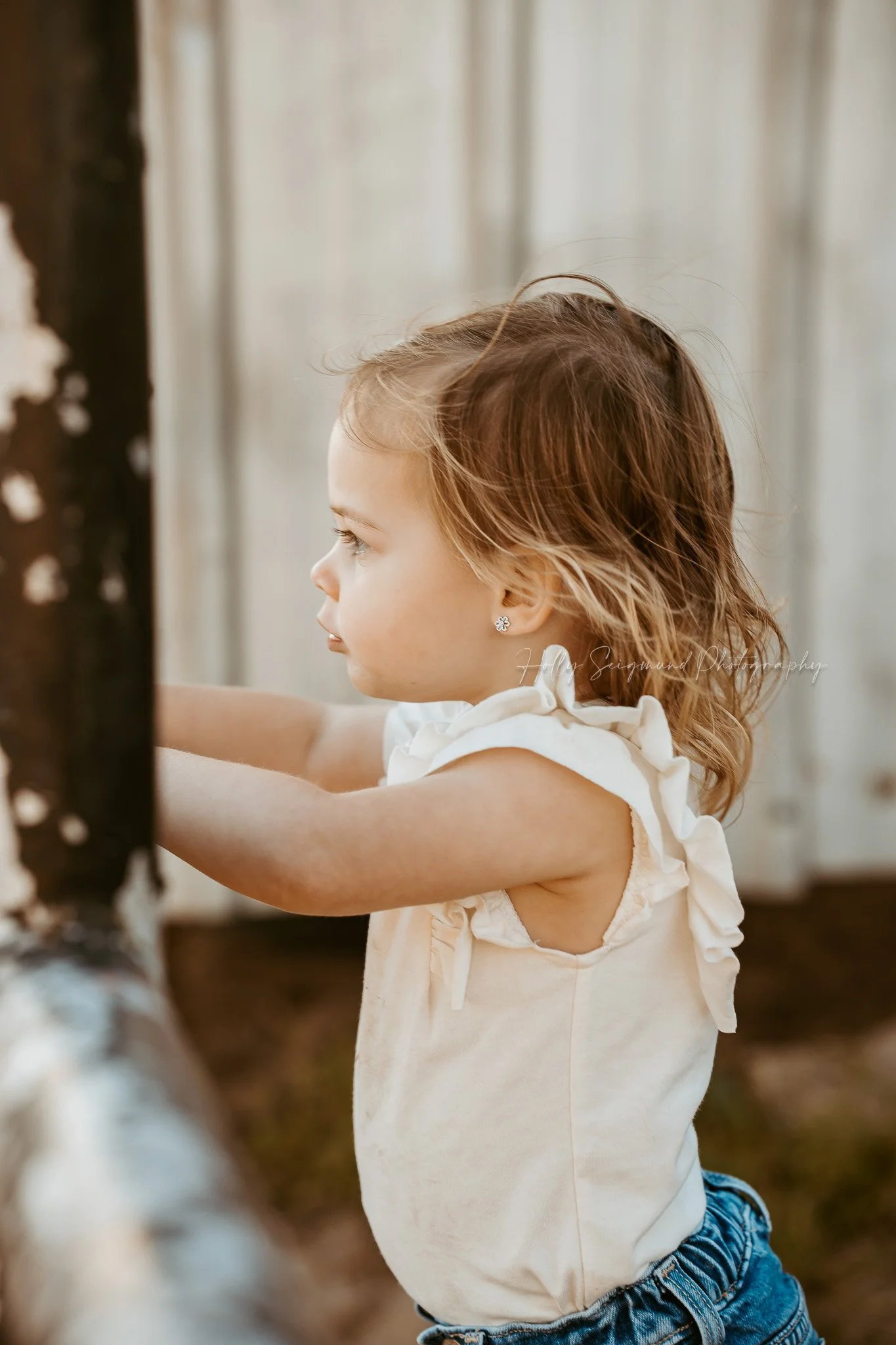 birthday girl standing looking at a pony in a rustic field in Texas during her photoshoot