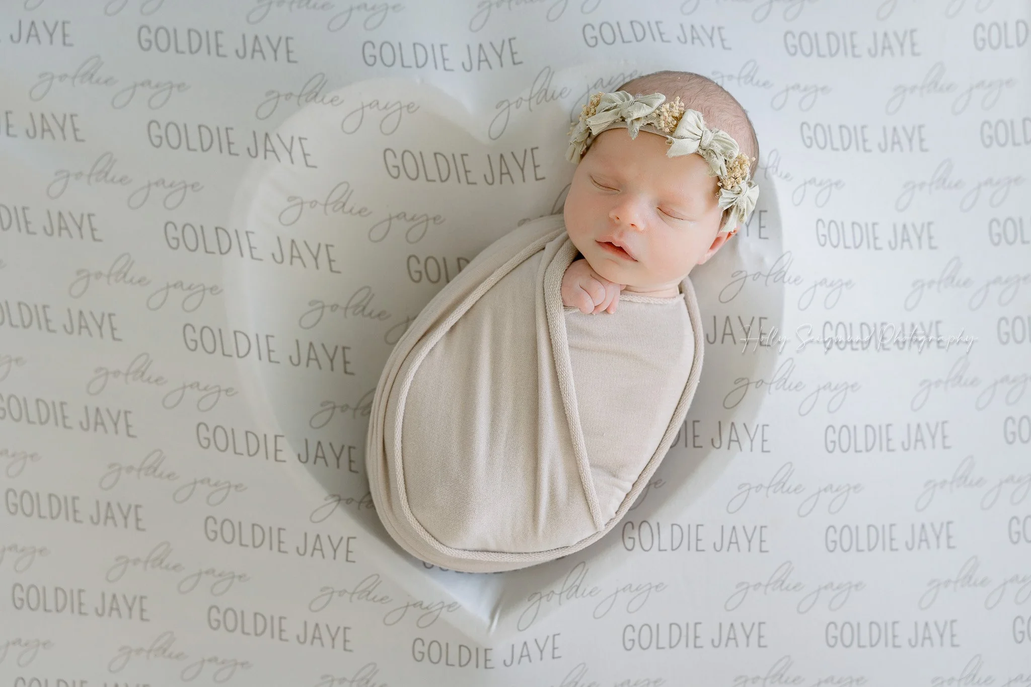 Newborn with a personalized blanket and heart bowl in a in-home newborn session in Central Texas