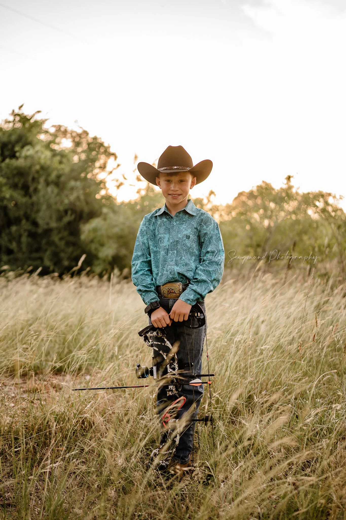 young boy celebrating his birthday with a bow hunting themed photoshoot in Lee County Texas